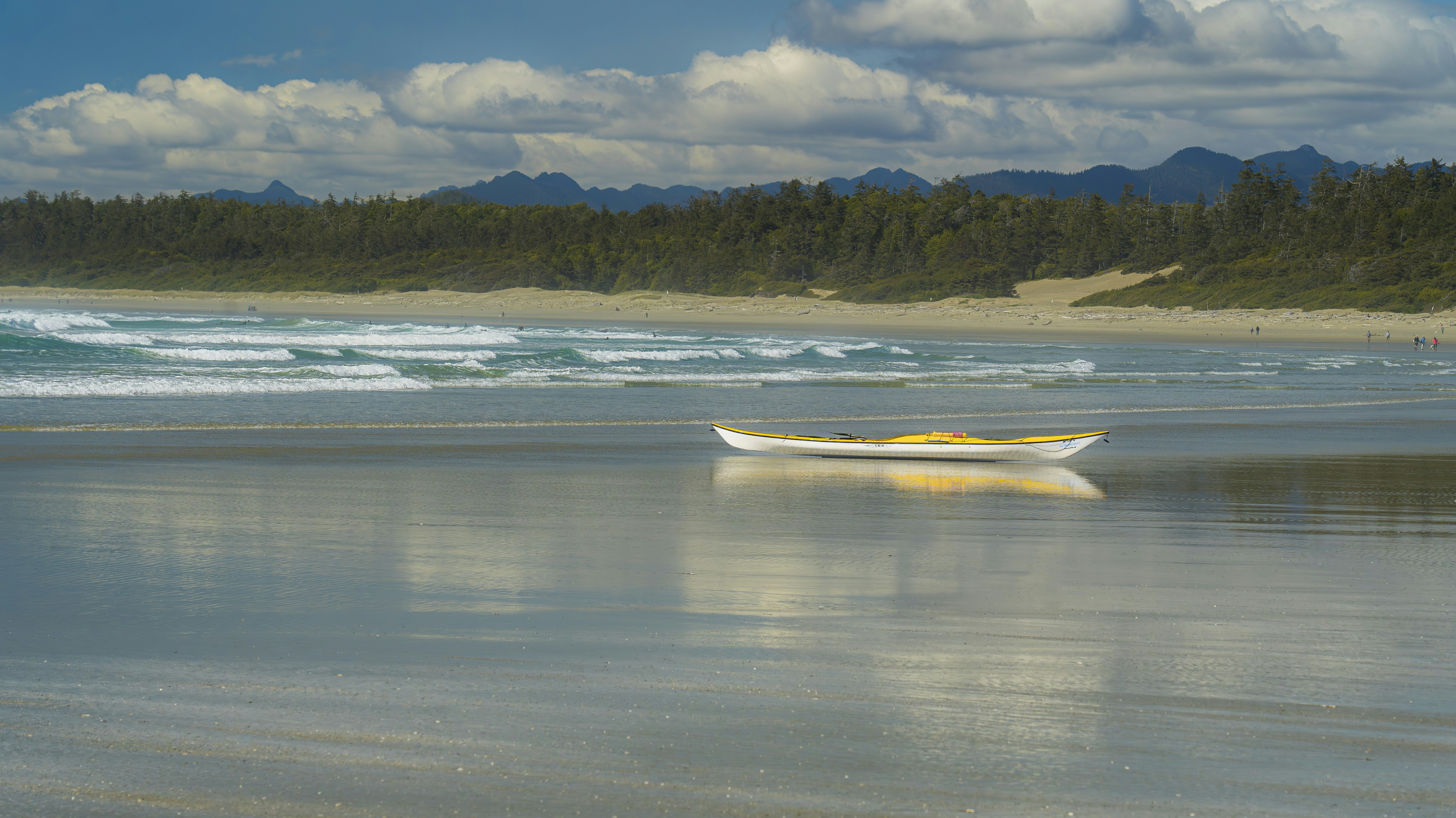A boat is sitting on the shore of a beach
