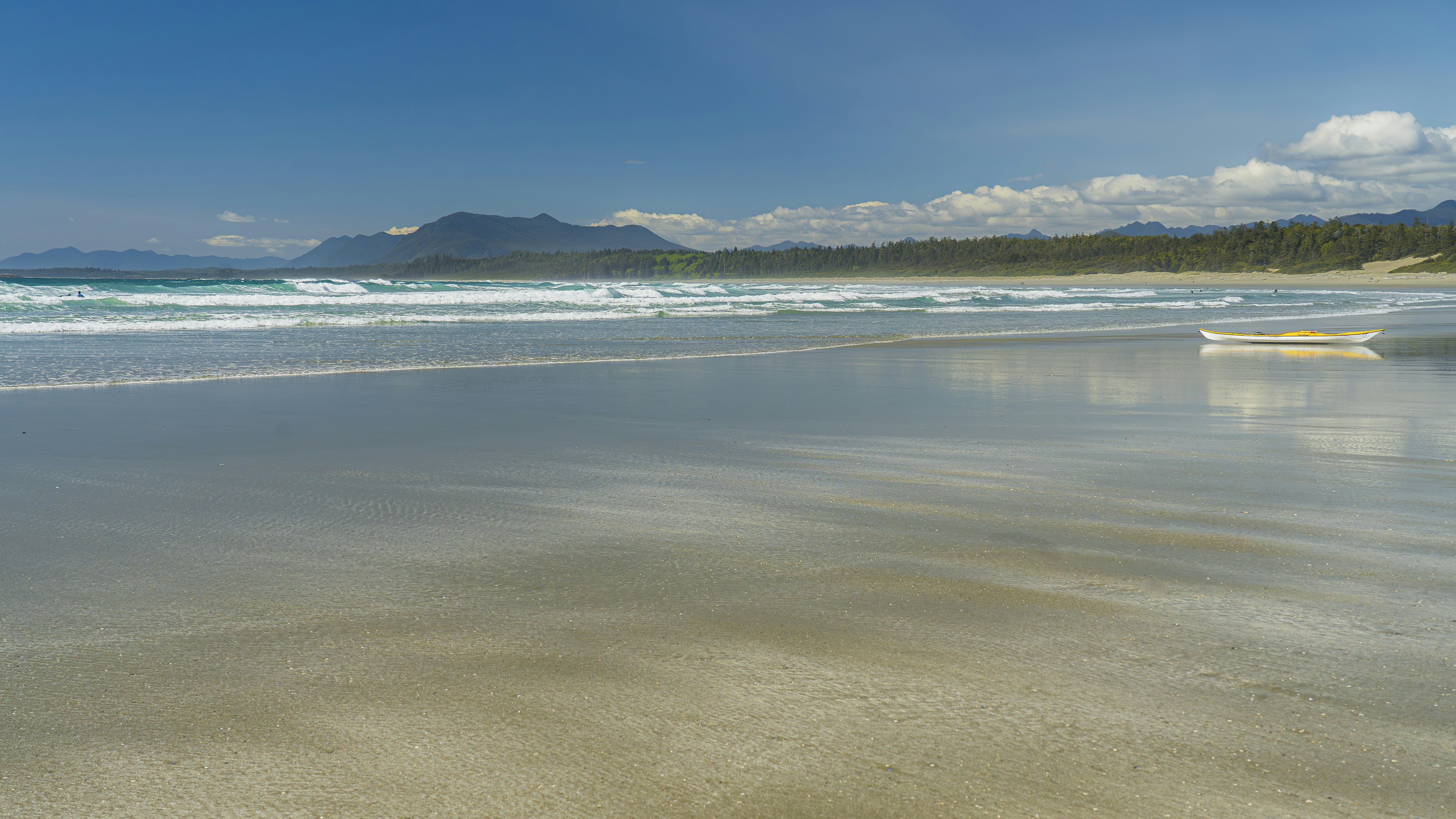 A sandy beach with a boat in the water
