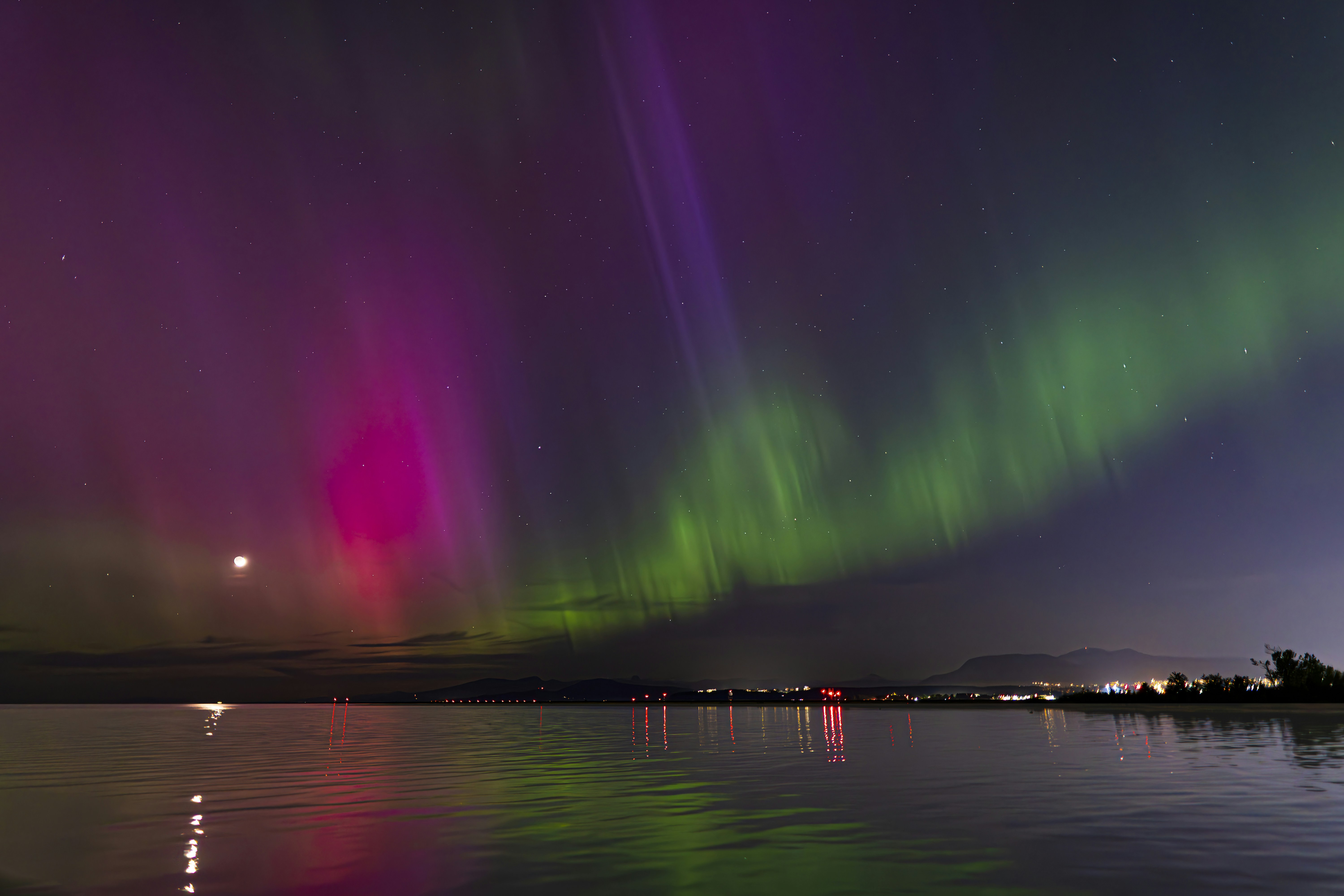 The aurora lights shine brightly over the water