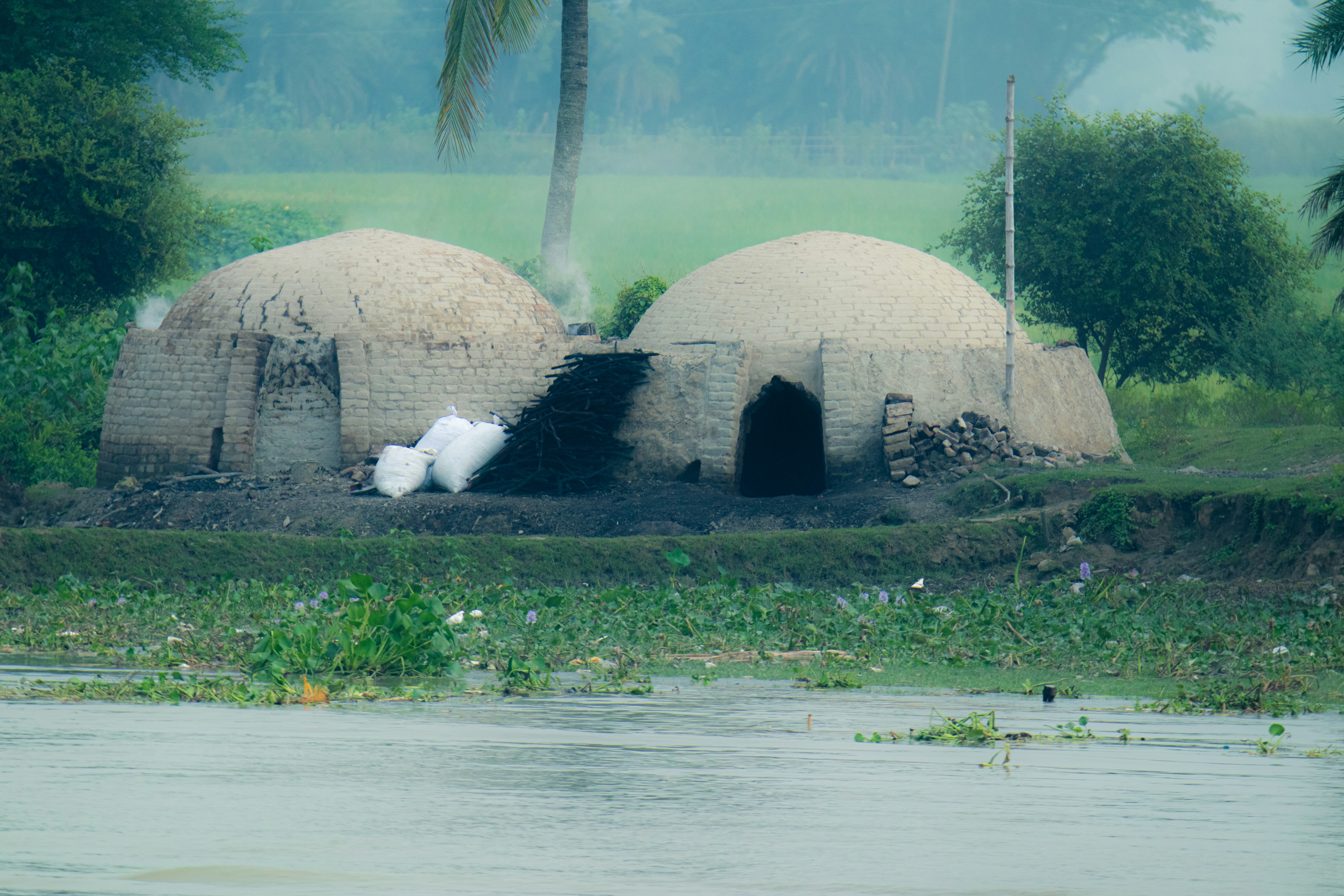 A couple of huts sitting on top of a lush green field