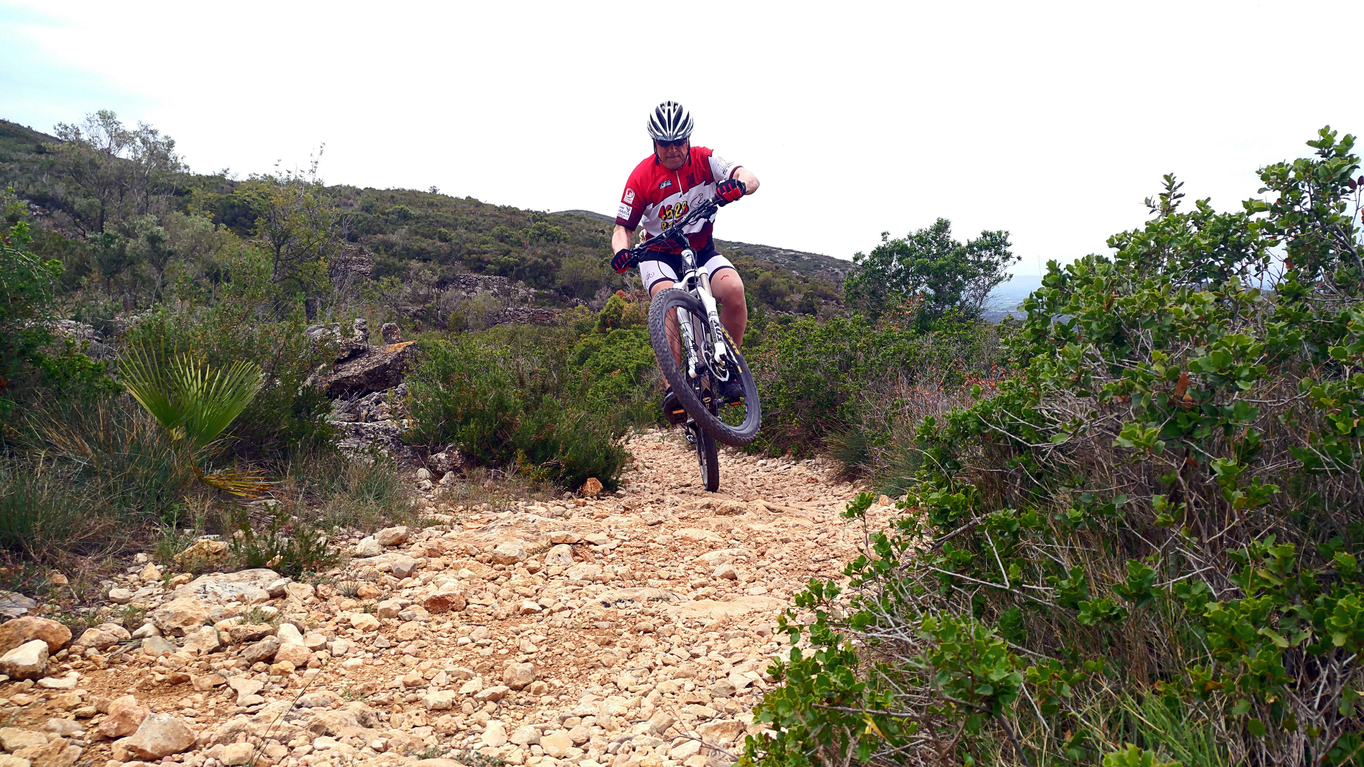 A man riding a bike down a dirt road