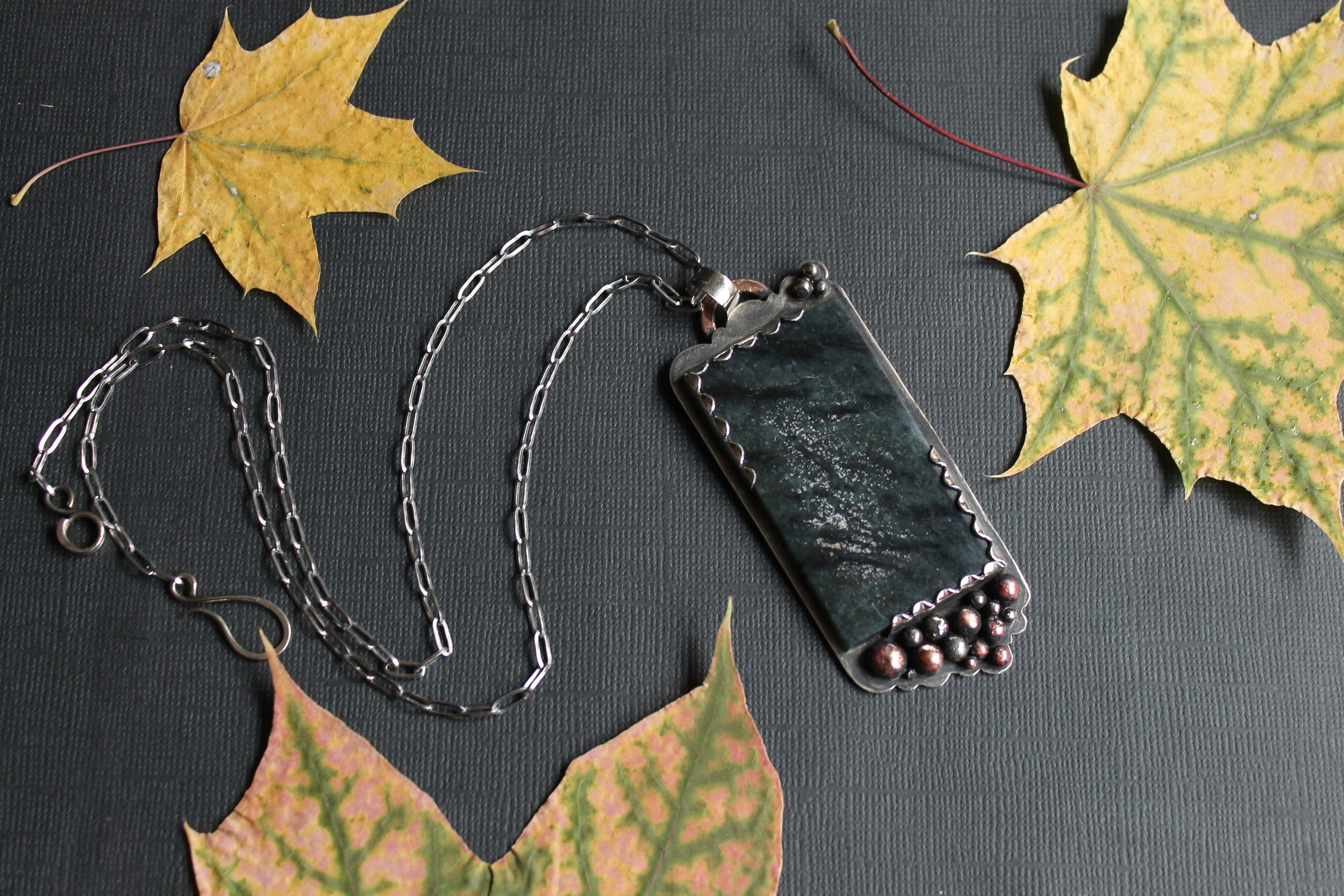 A picture of a necklace and some leaves