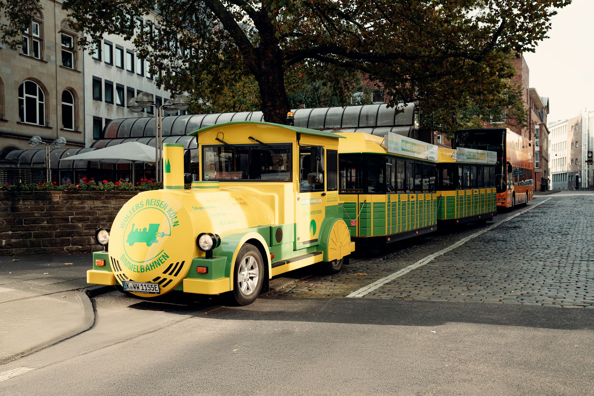 A yellow and green bus driving down a street