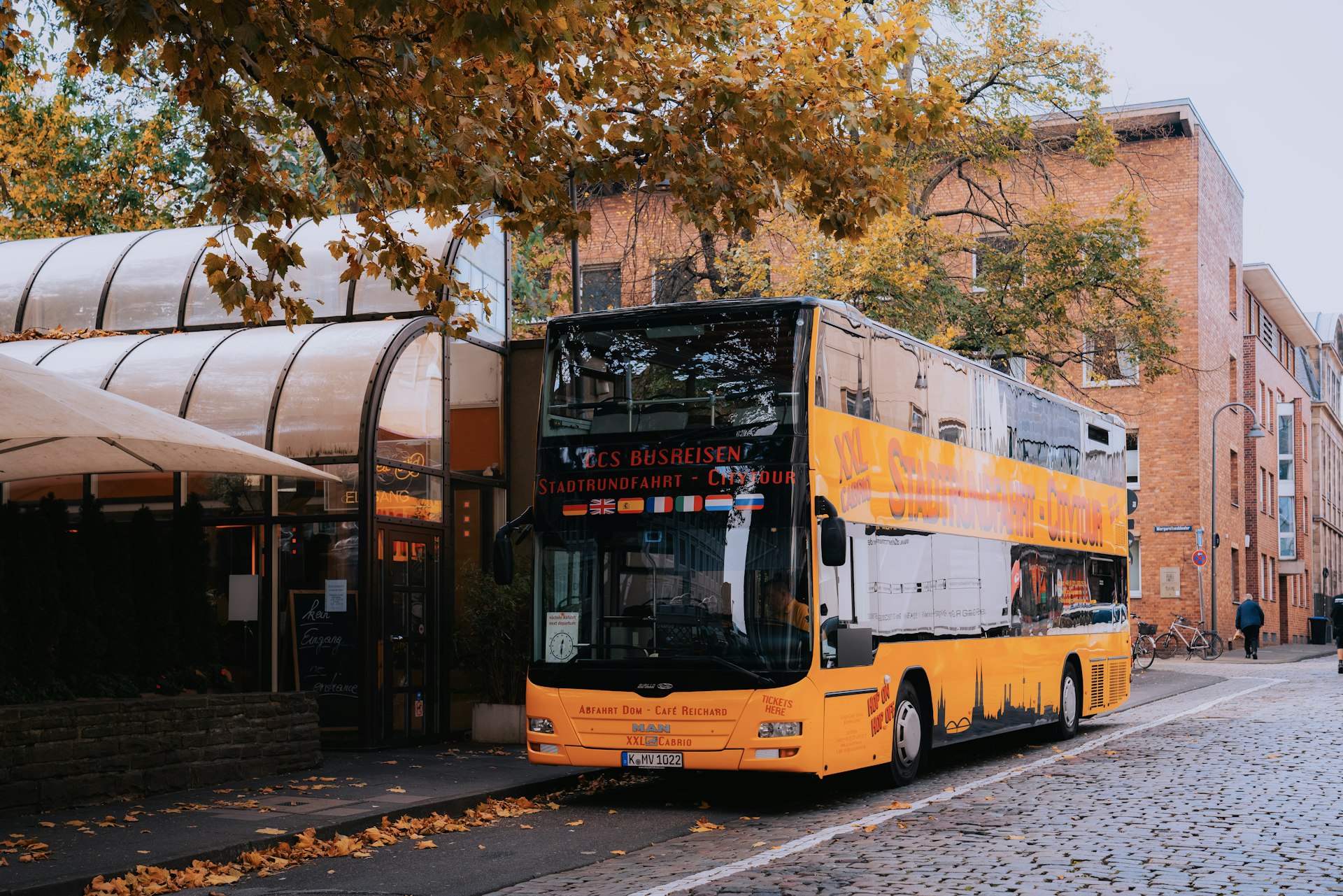 A yellow double decker bus parked on the side of the road
