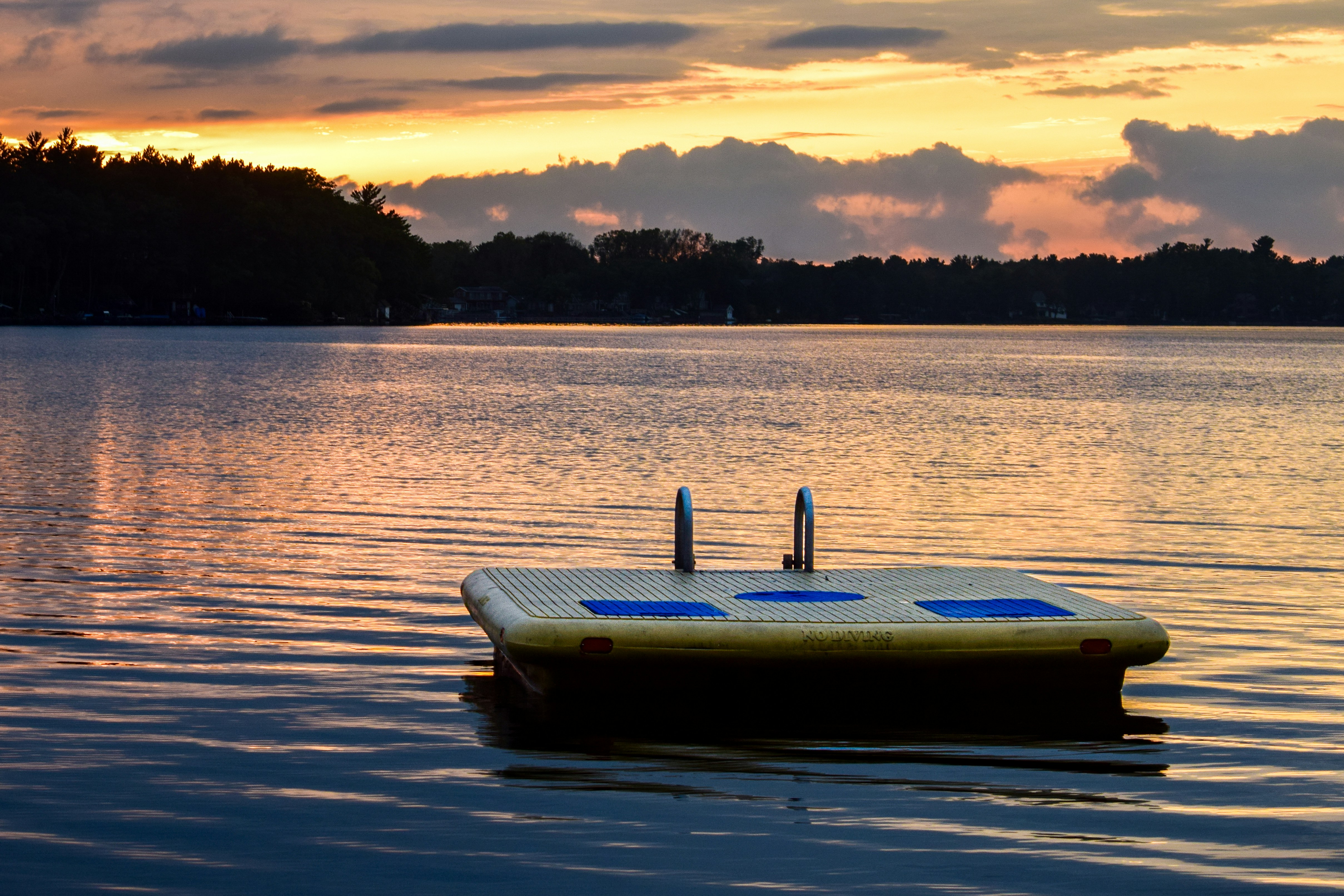 Un bateau flottant à la surface d’un lac sous un ciel nuageux