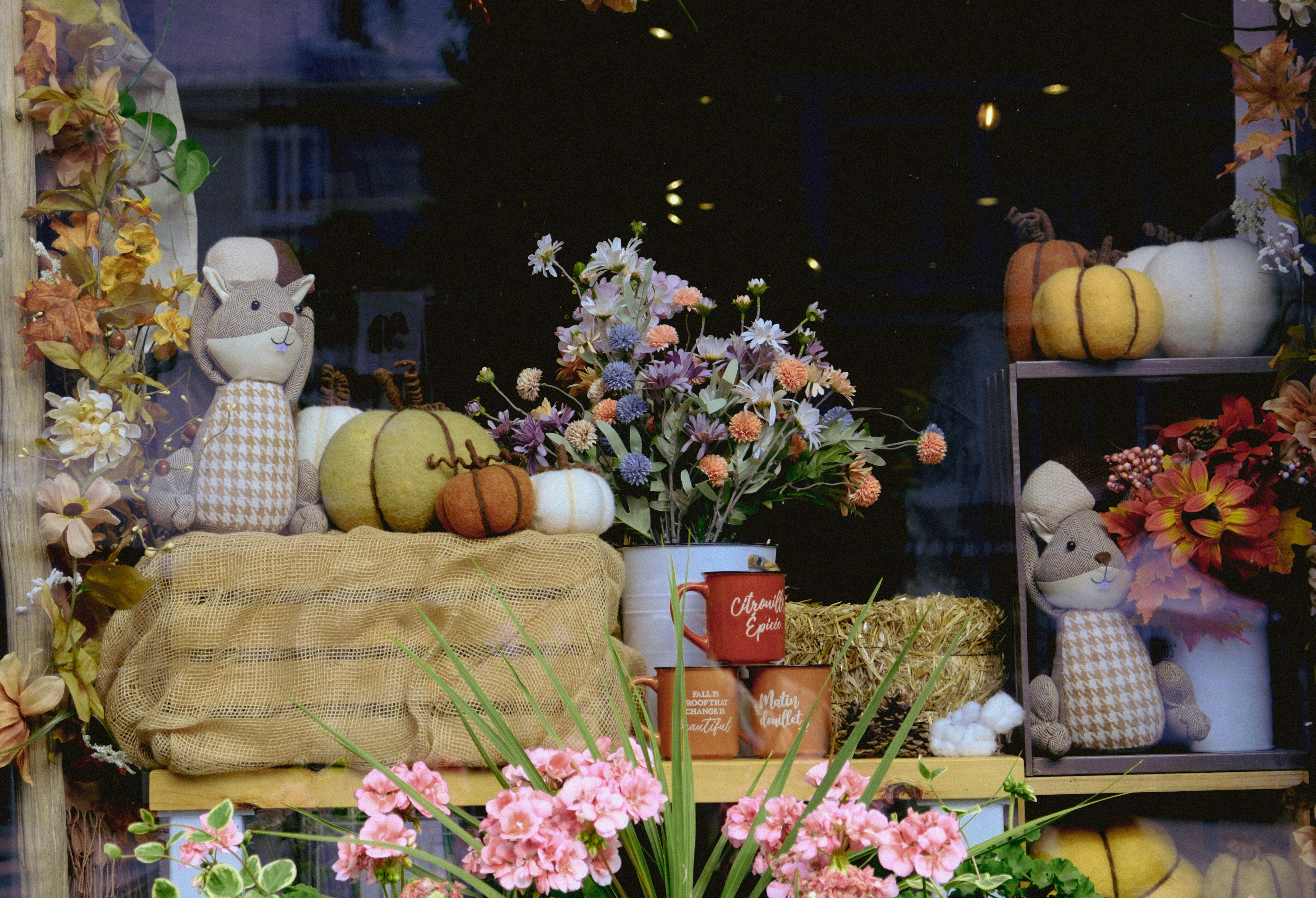 A window display with flowers and stuffed animals