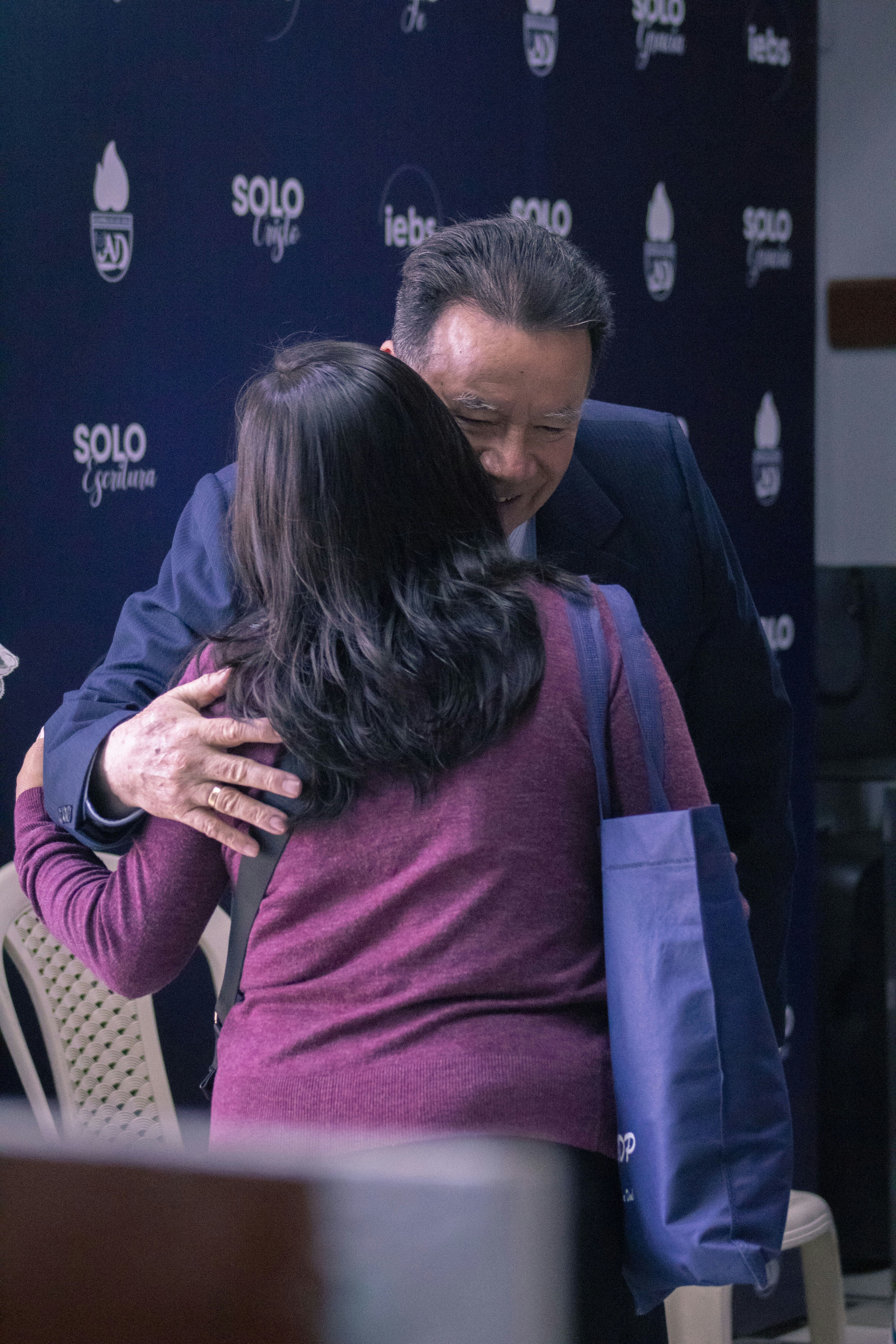A man and woman hug each other in front of a microphone photo – Free ...