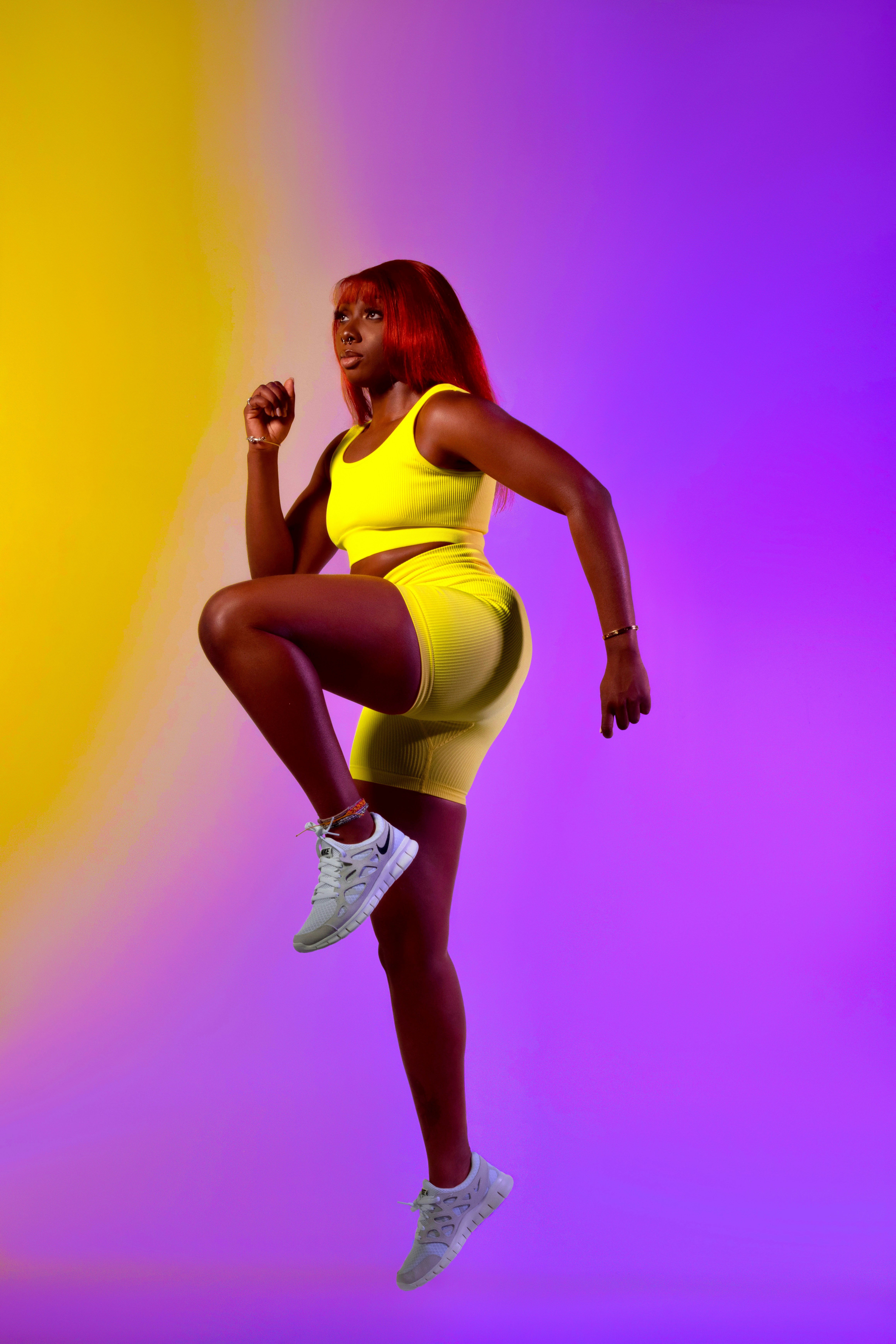 Eine Frau in einem gelben Kleid, die in die Luft springt