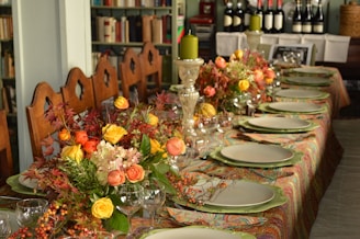 A long table is set with plates and flowers