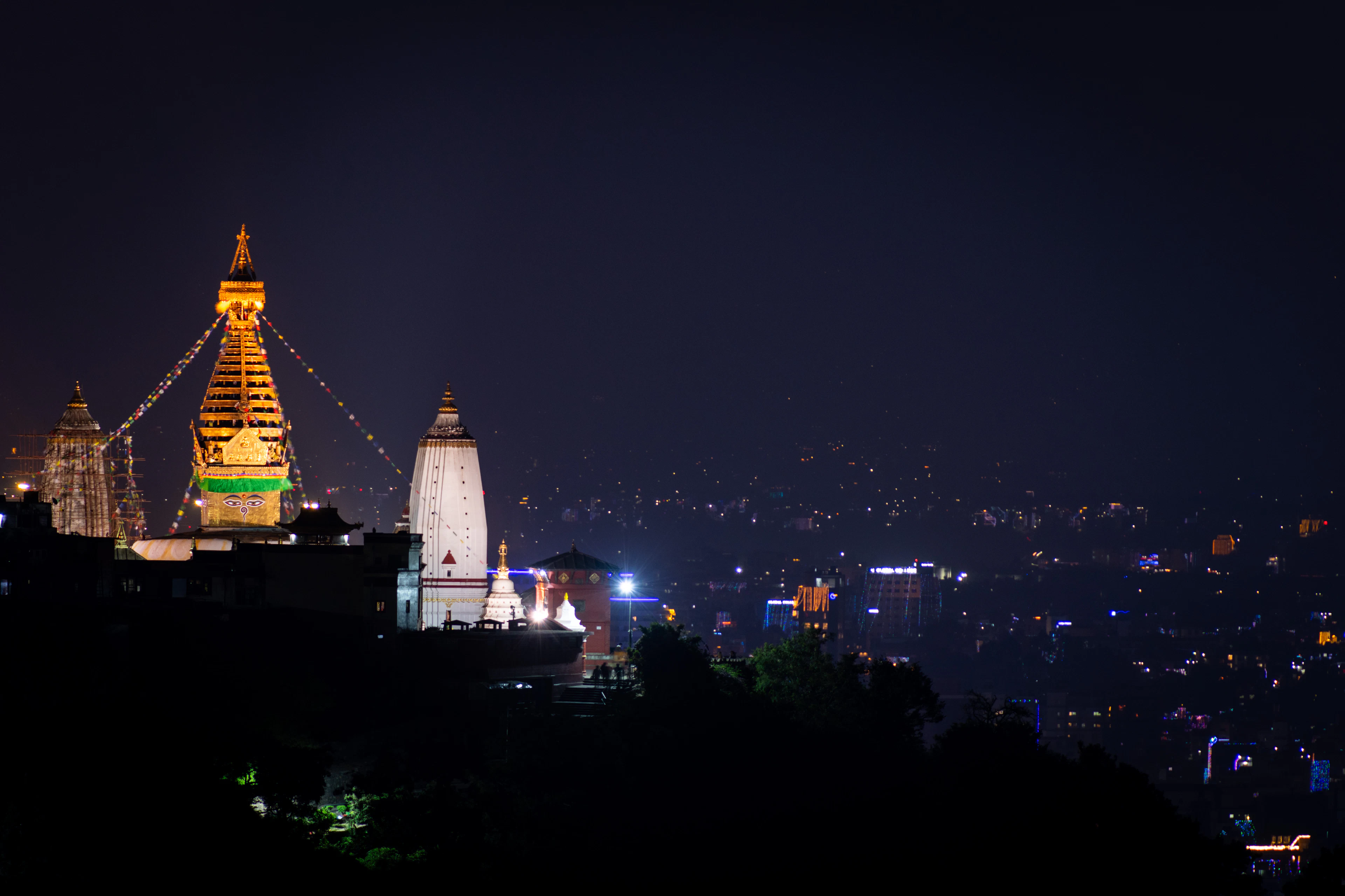 Swayambhunath stupa lit up at night on its hill above Kathmandu