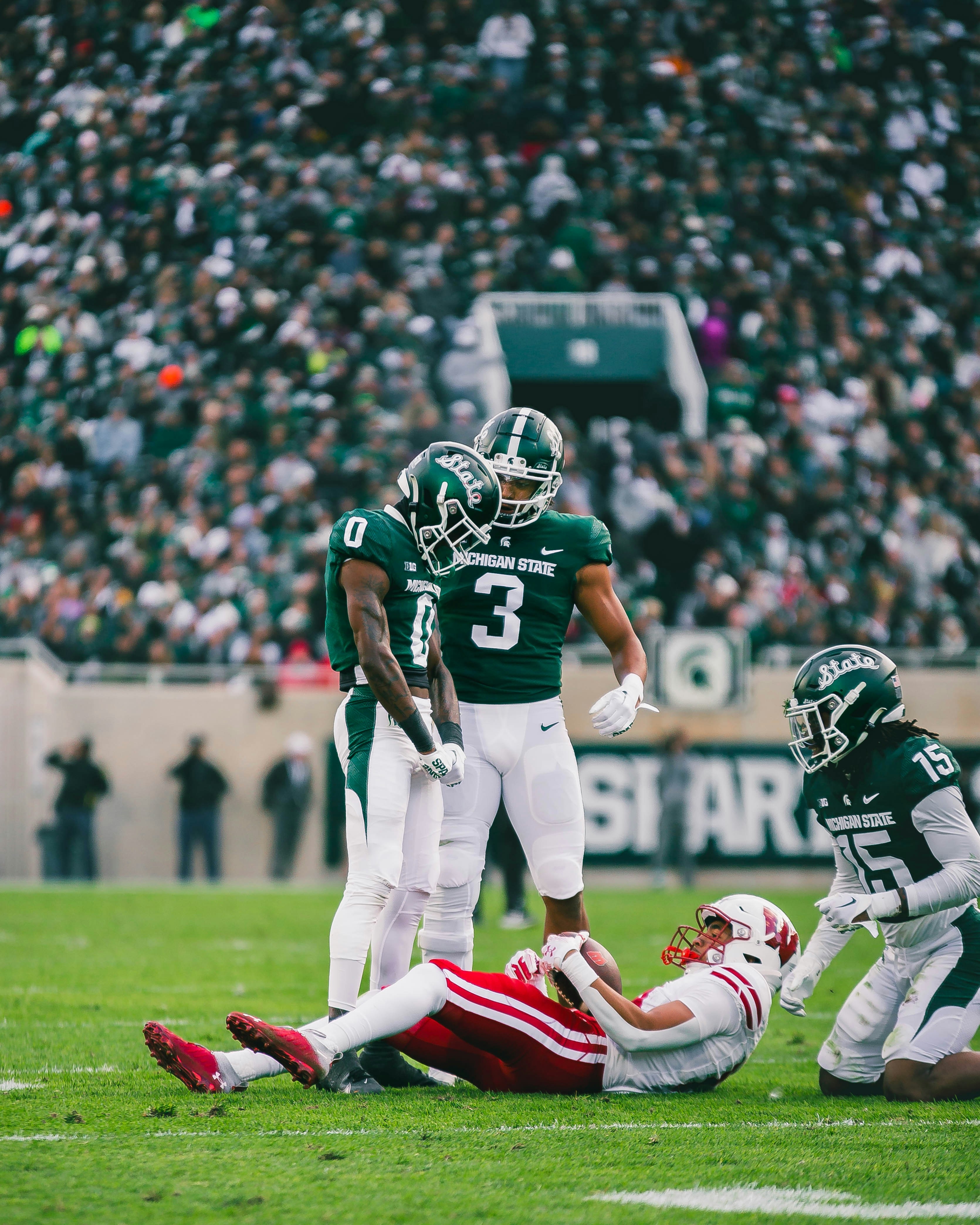 A group of football players standing on top of a field