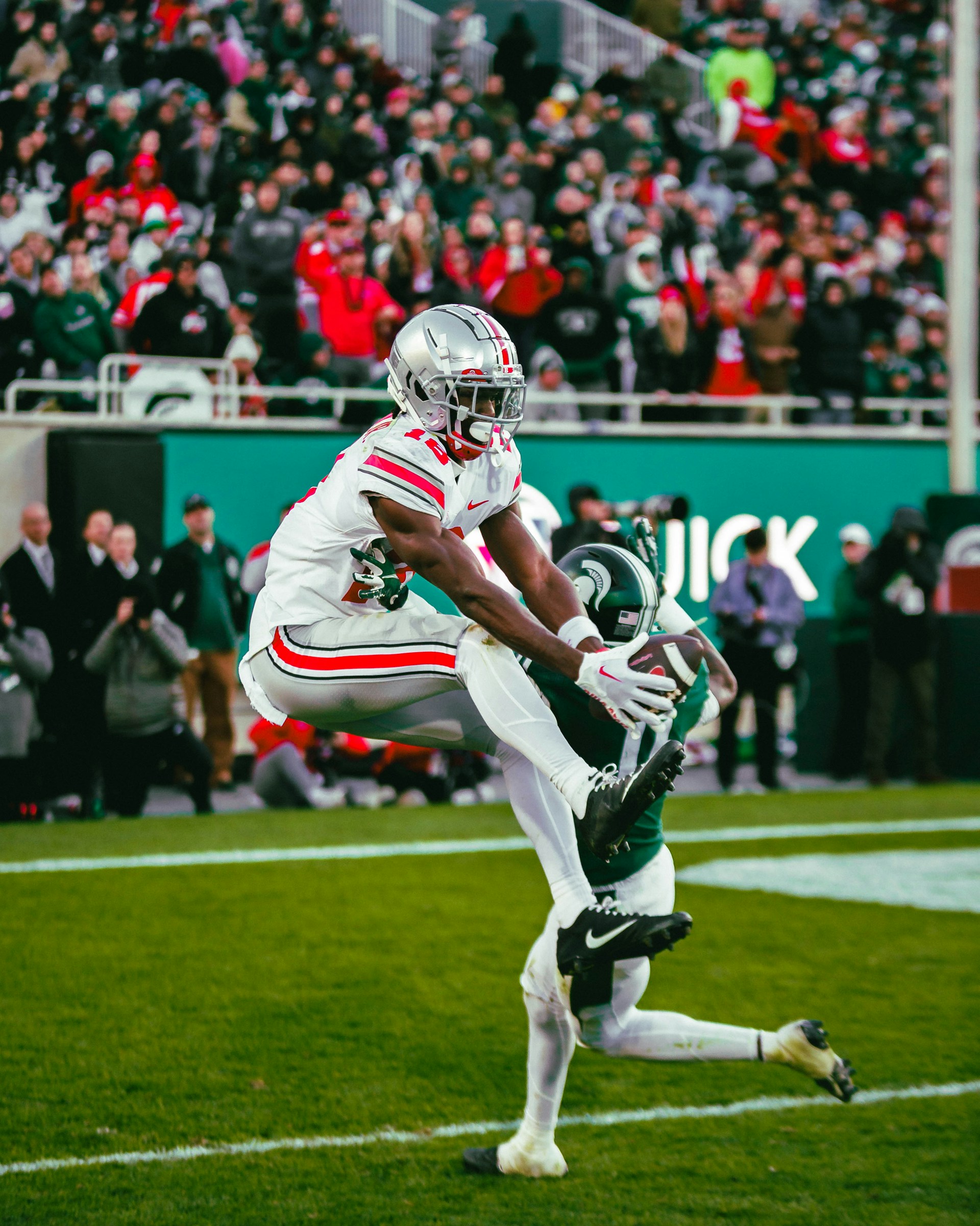 A football player running with a football on a field