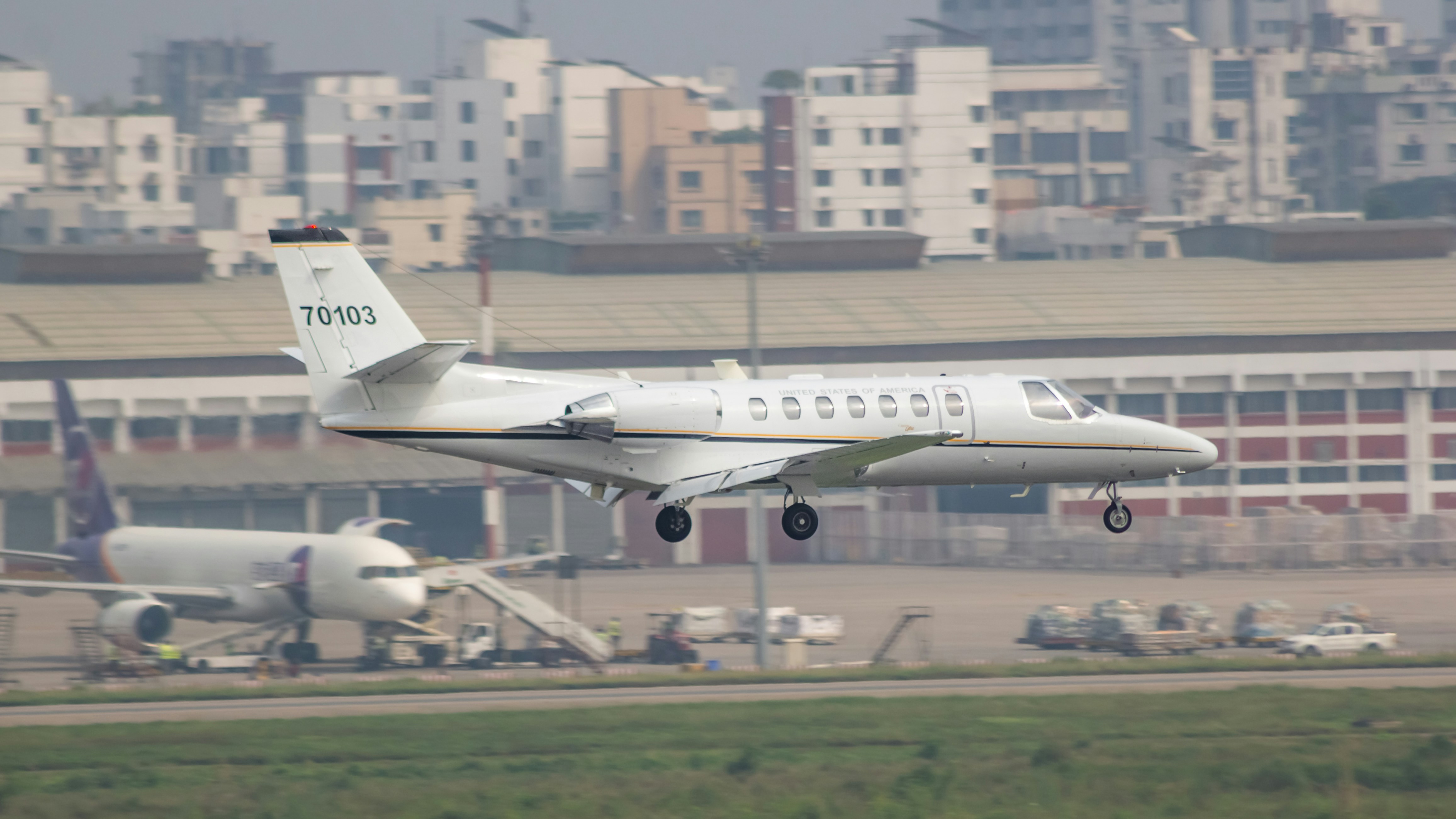 A white plane taking off from an airport runway, US Army Cessna Citation Ultra in Dhaka.