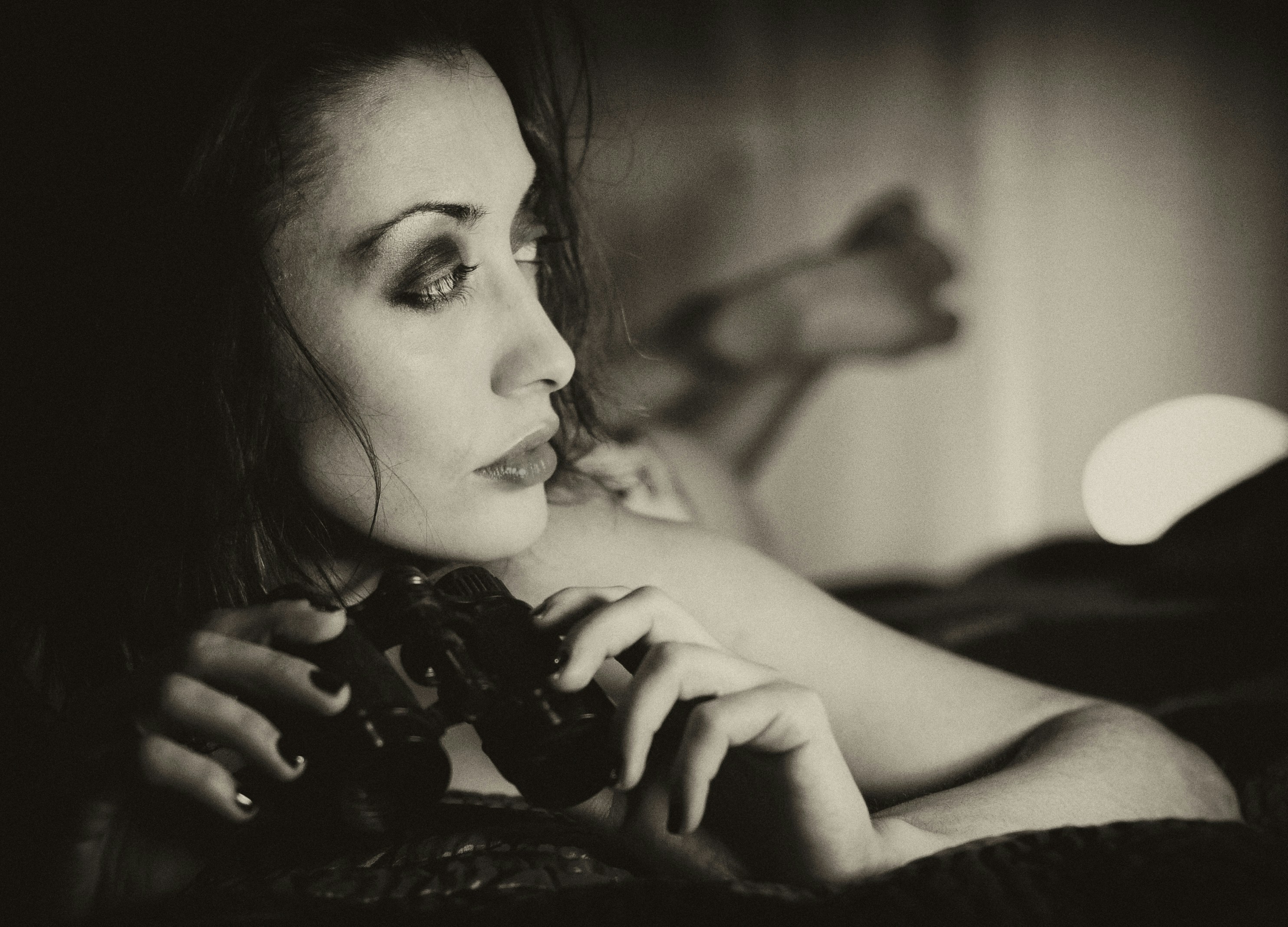 A black and white photo of a woman holding a camera