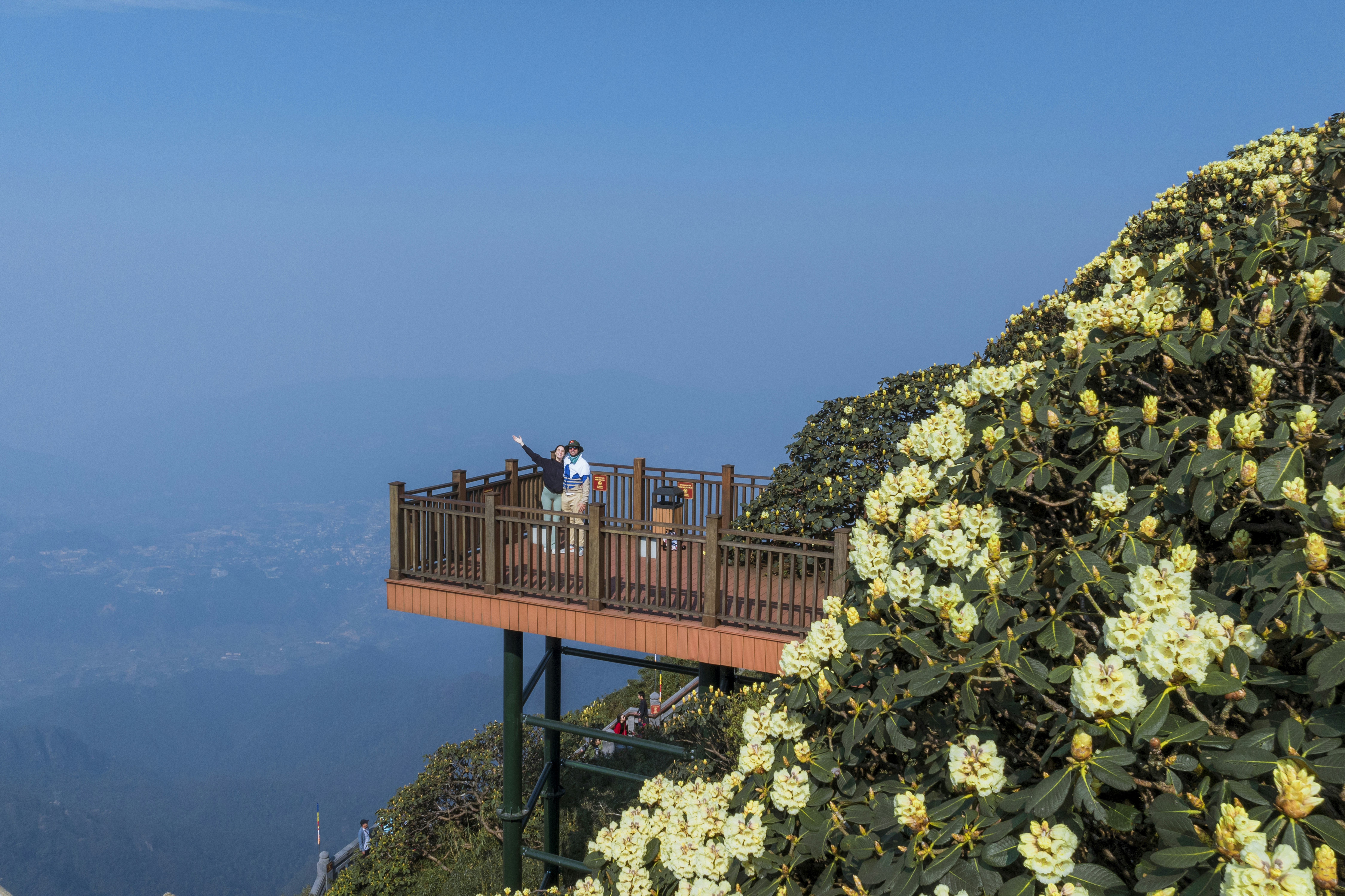 A group of people standing on top of a wooden bridge