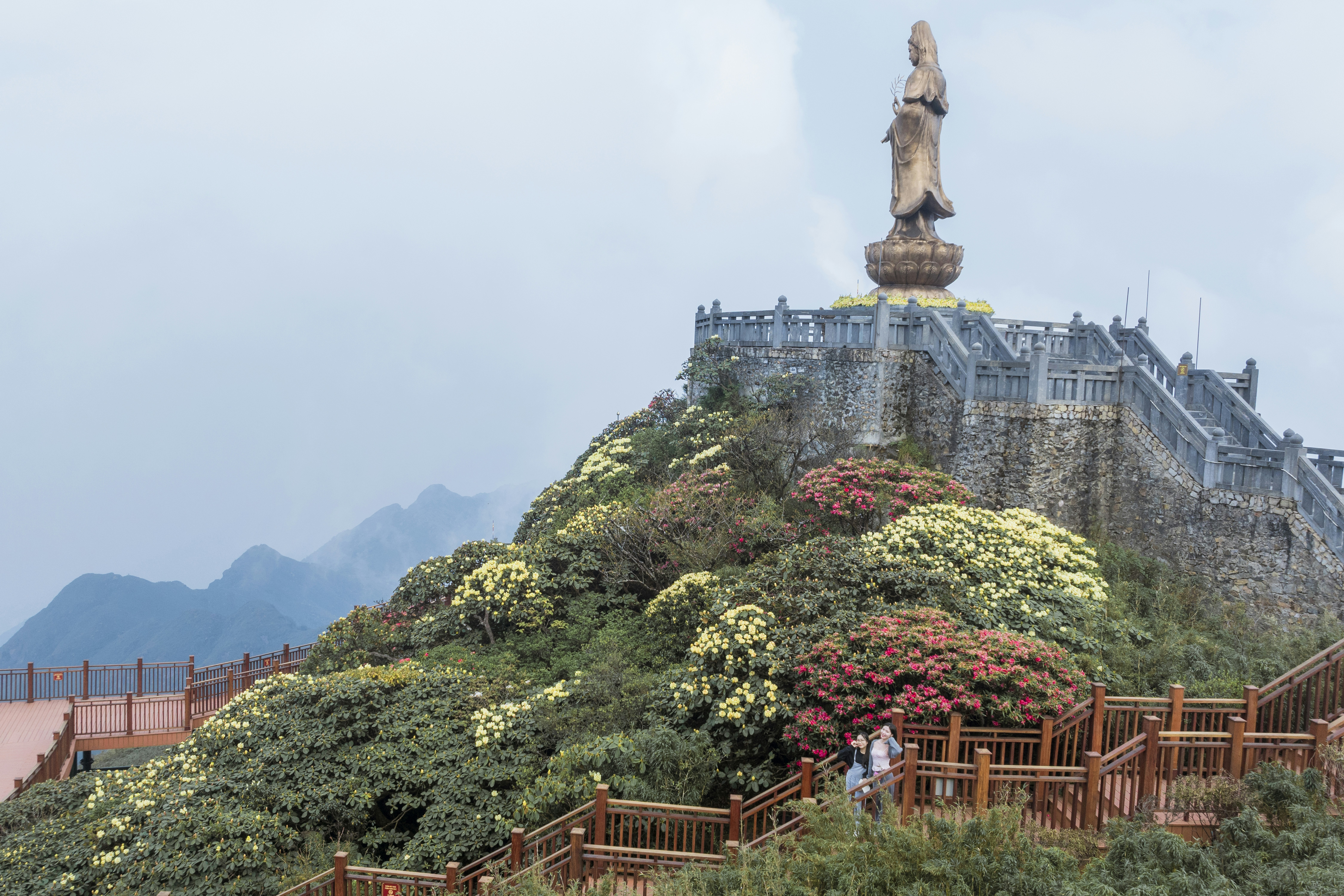 A statue on top of a hill in the middle of a park