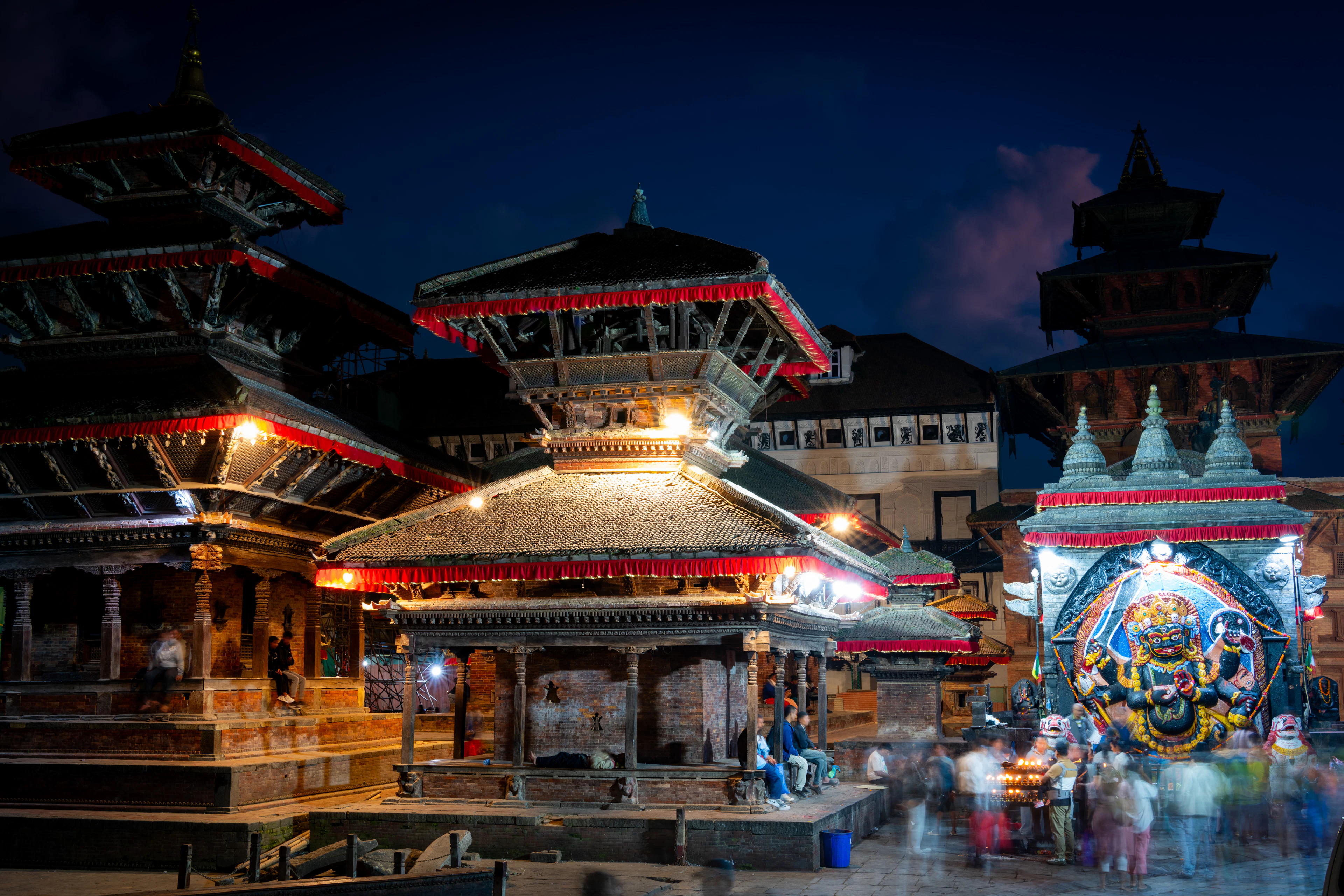 Pagoda-style temples in Kathmandu's Durbar Square, lit up at dusk