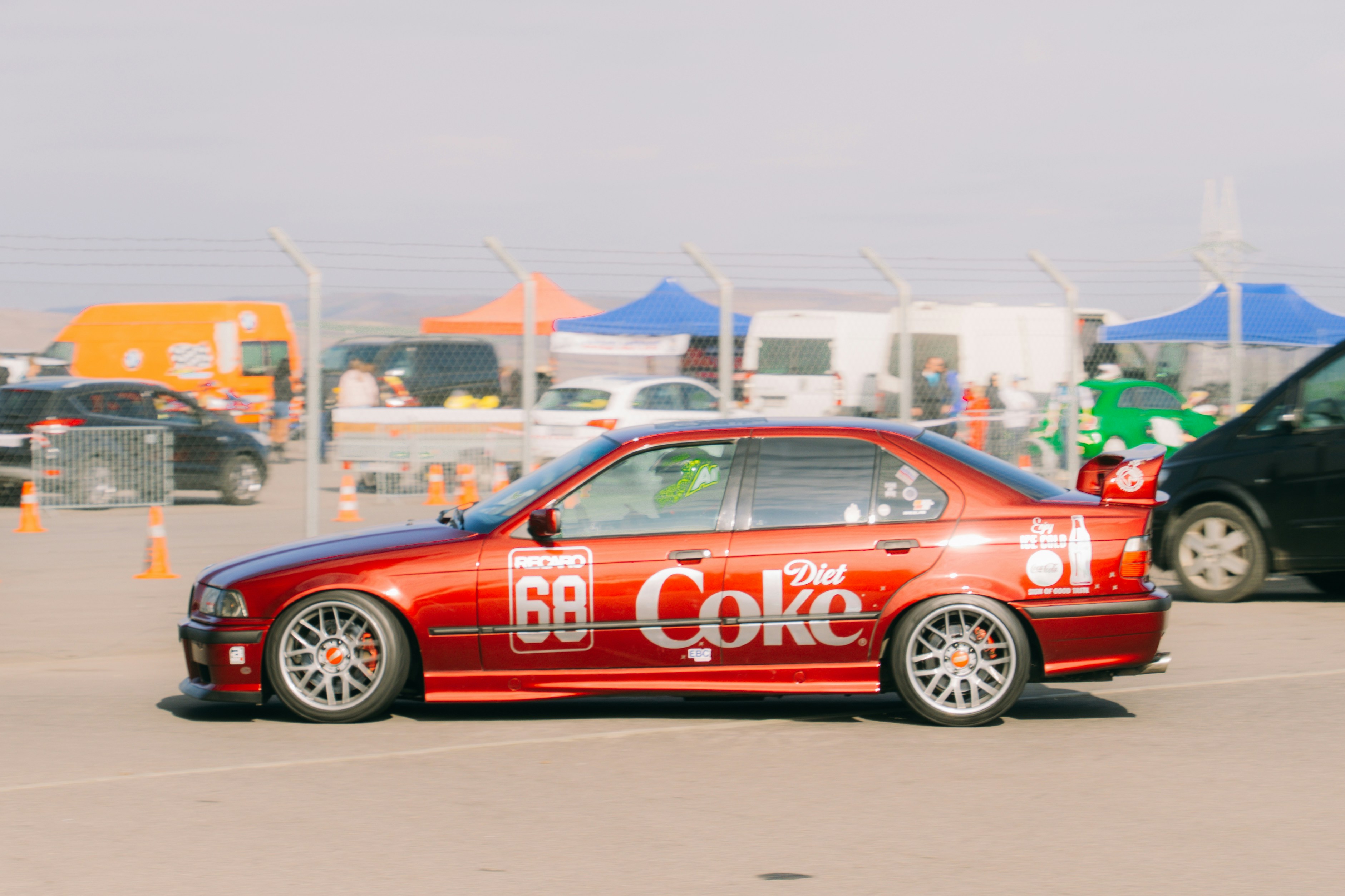 A red car is parked in a parking lot