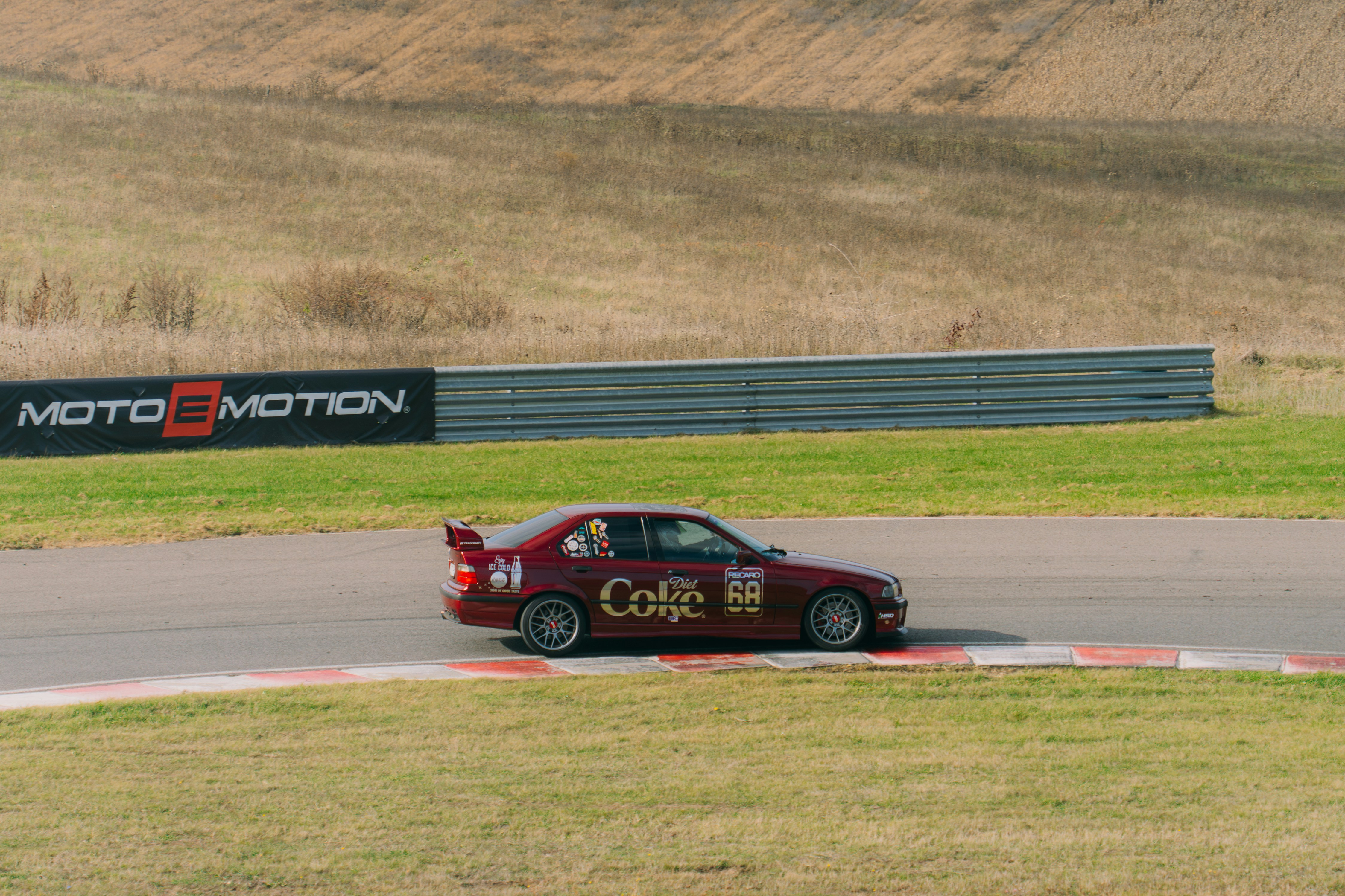 A red car driving down a race track