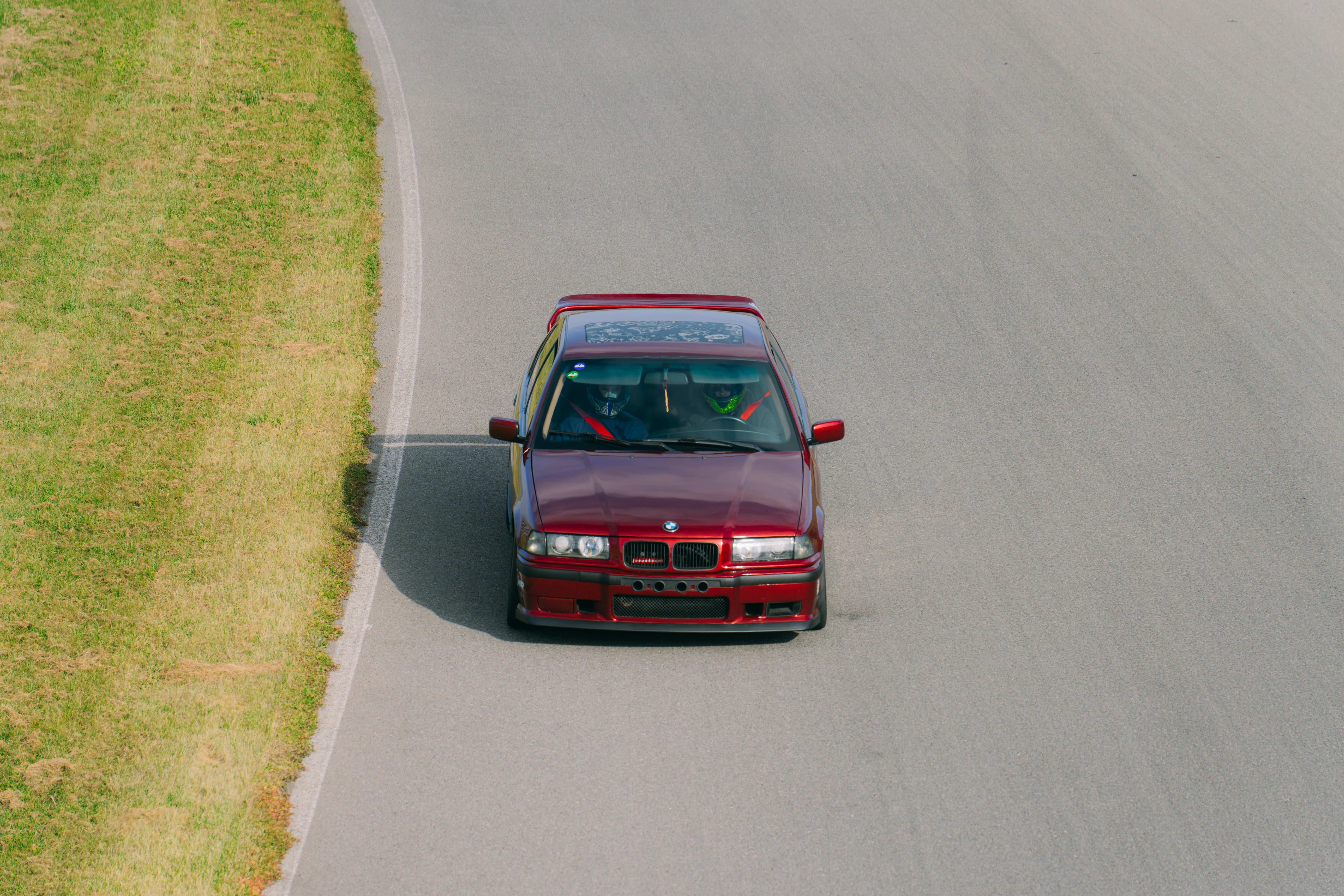 A red car driving down a winding road