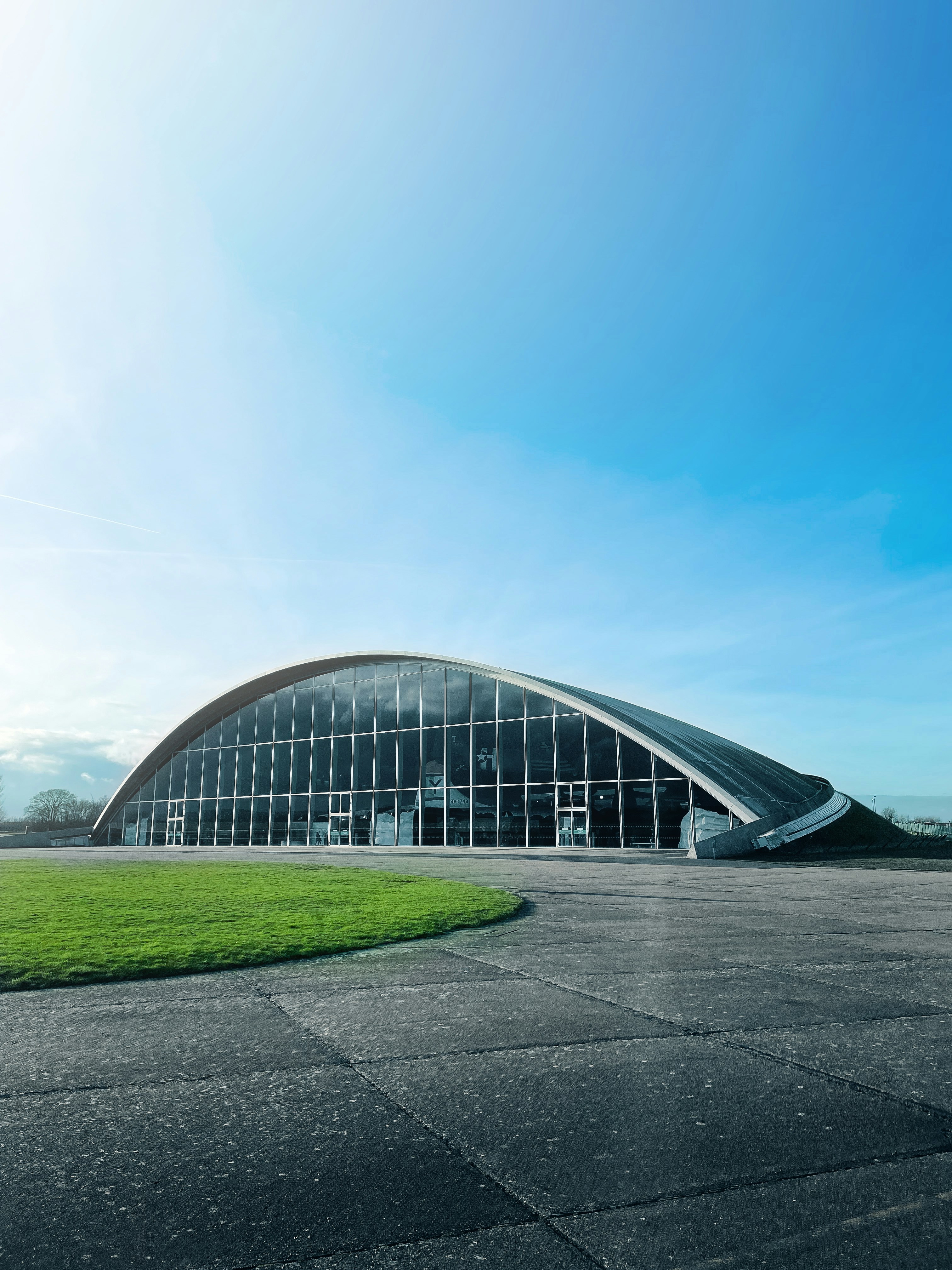 A large building with a curved roof on a sunny day