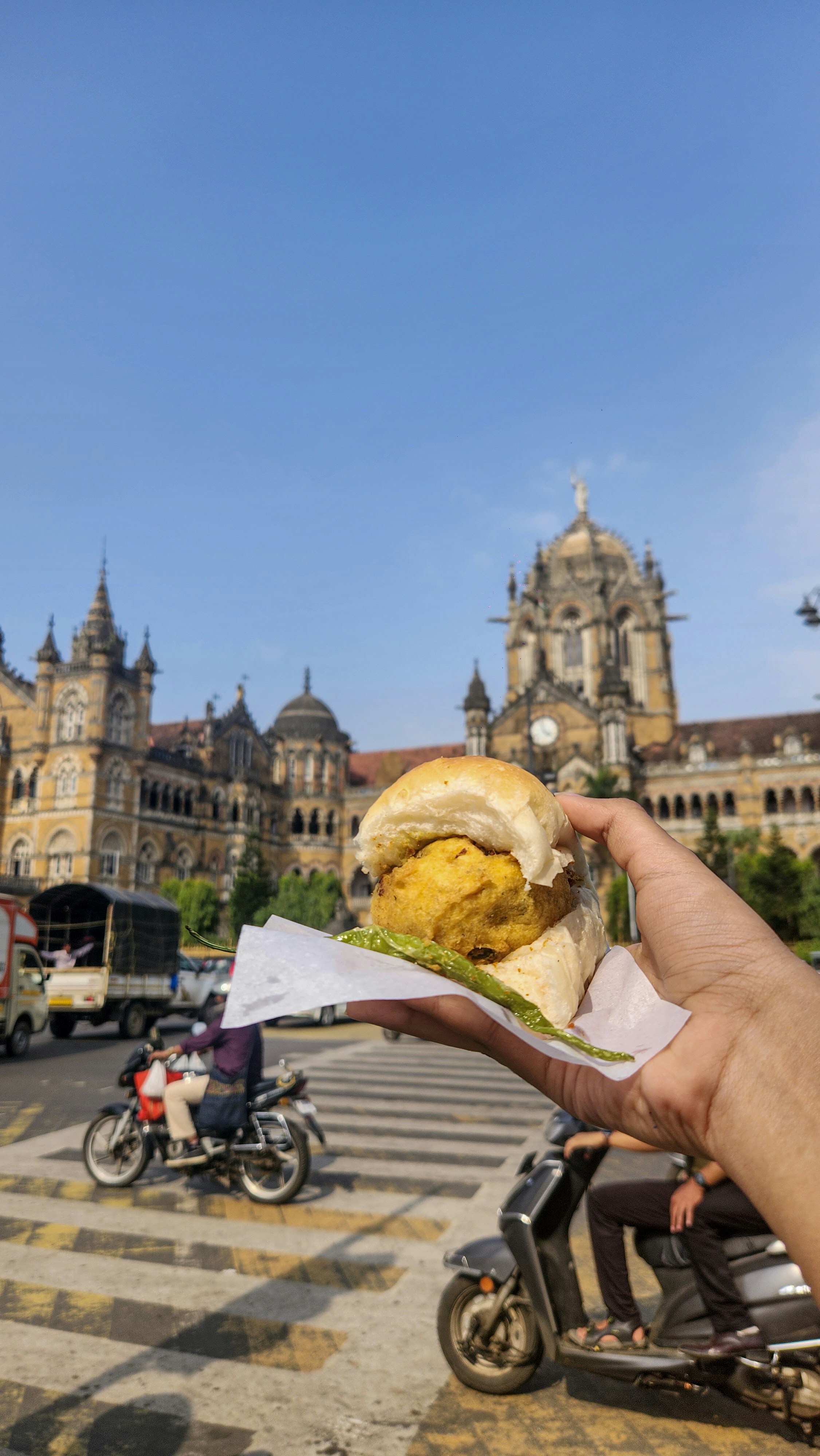 Mumbai vada pav close-up, golden fried batata vada in soft pav bun with green chutney, bright vibrant food photography, white background