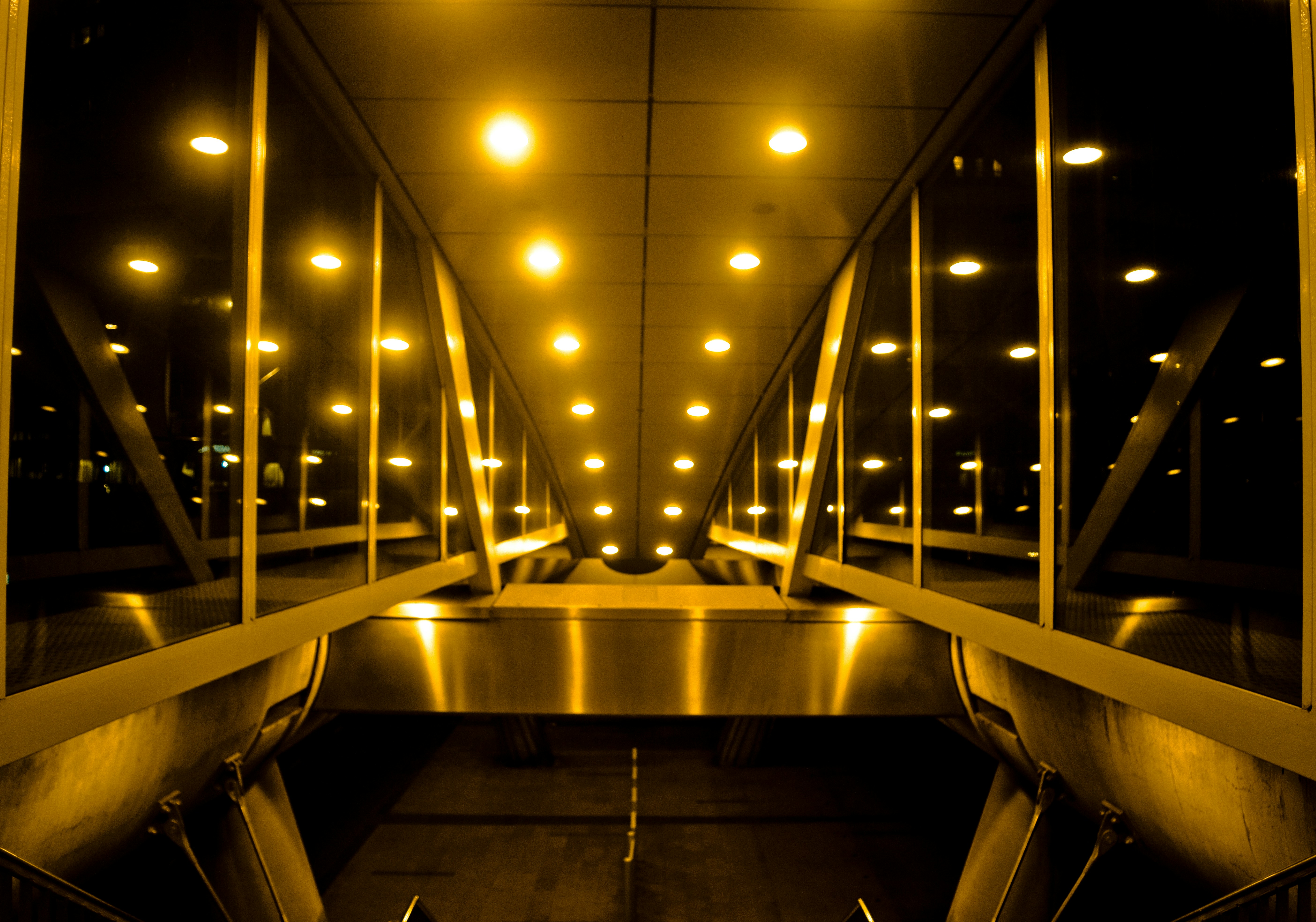 A very long walkway with some lights on it
