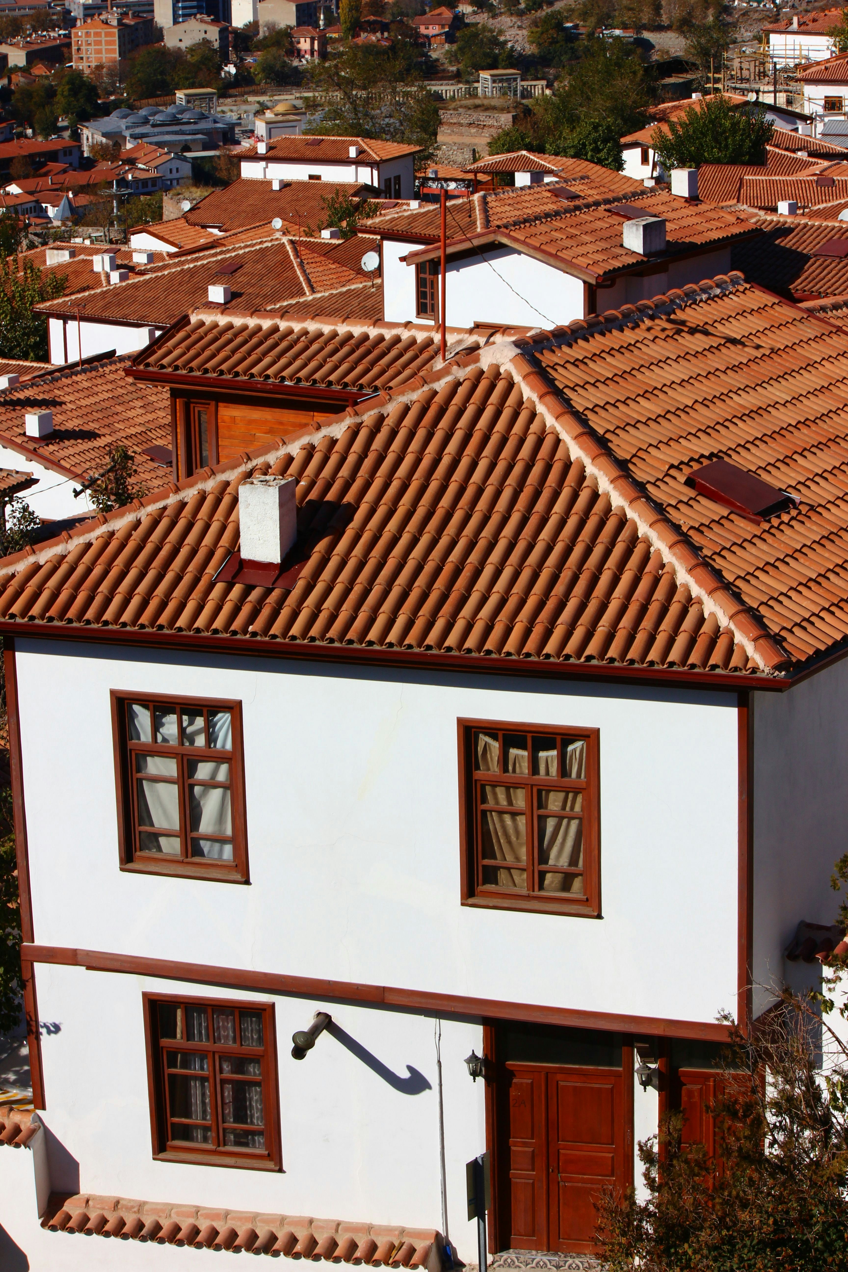 A white house with a brown roof and a red tiled roof photo – Free Kale ...