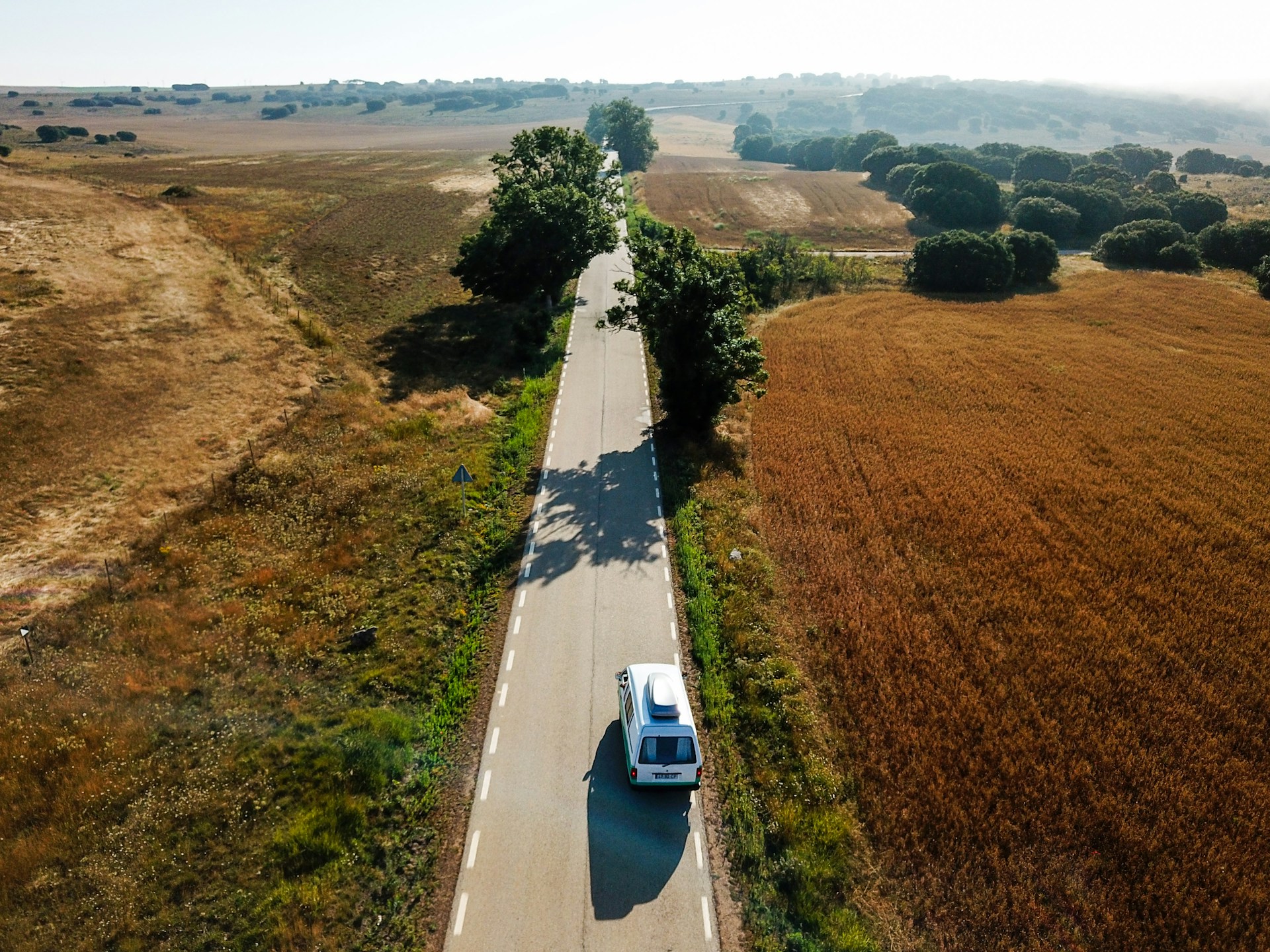 An aerial view of a car driving down a road