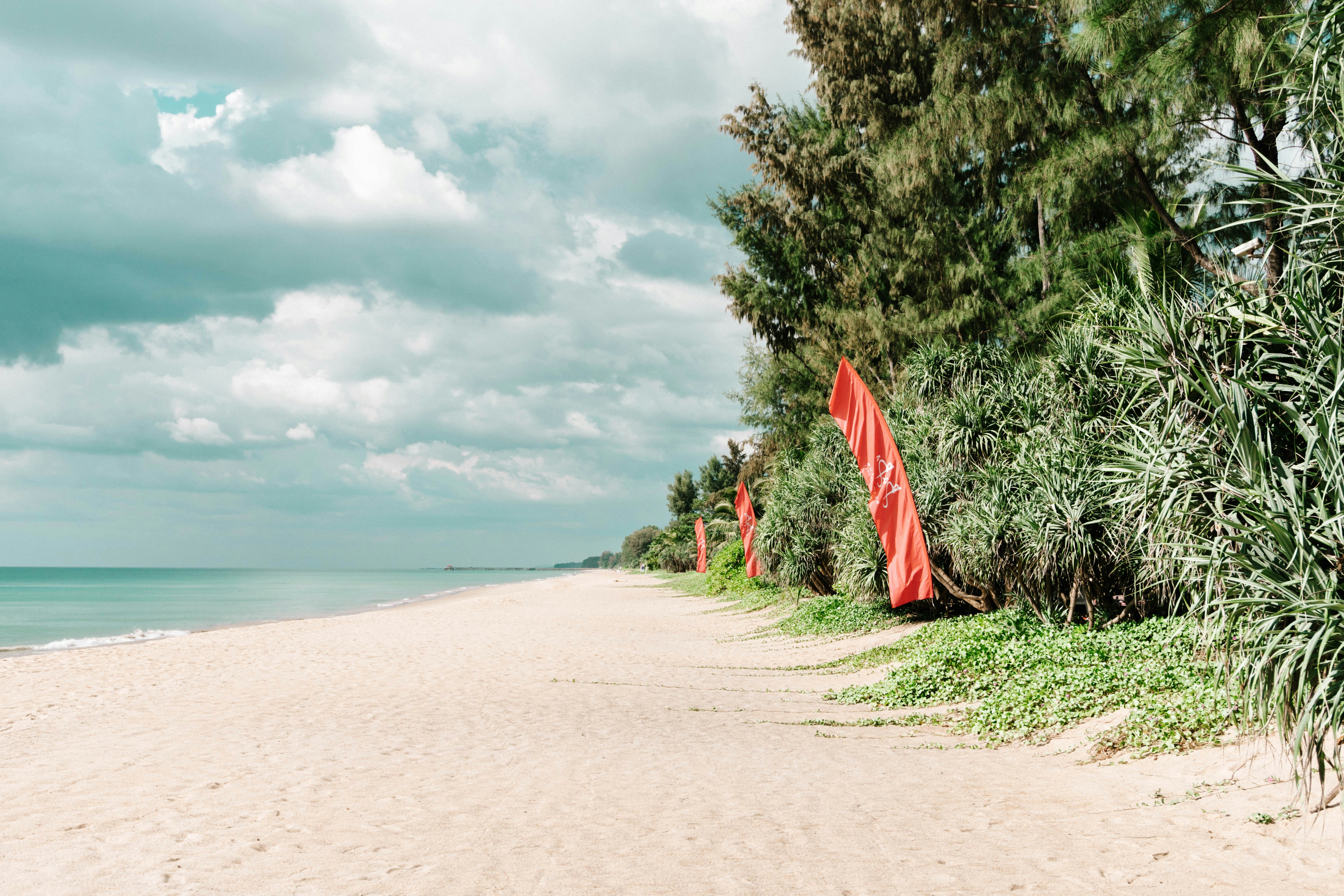 A sandy beach next to the ocean under a cloudy sky