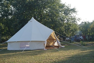 A large white tent sitting on top of a lush green field