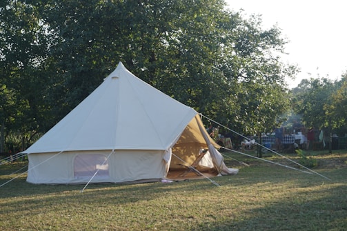 A large white tent sitting on top of a lush green field