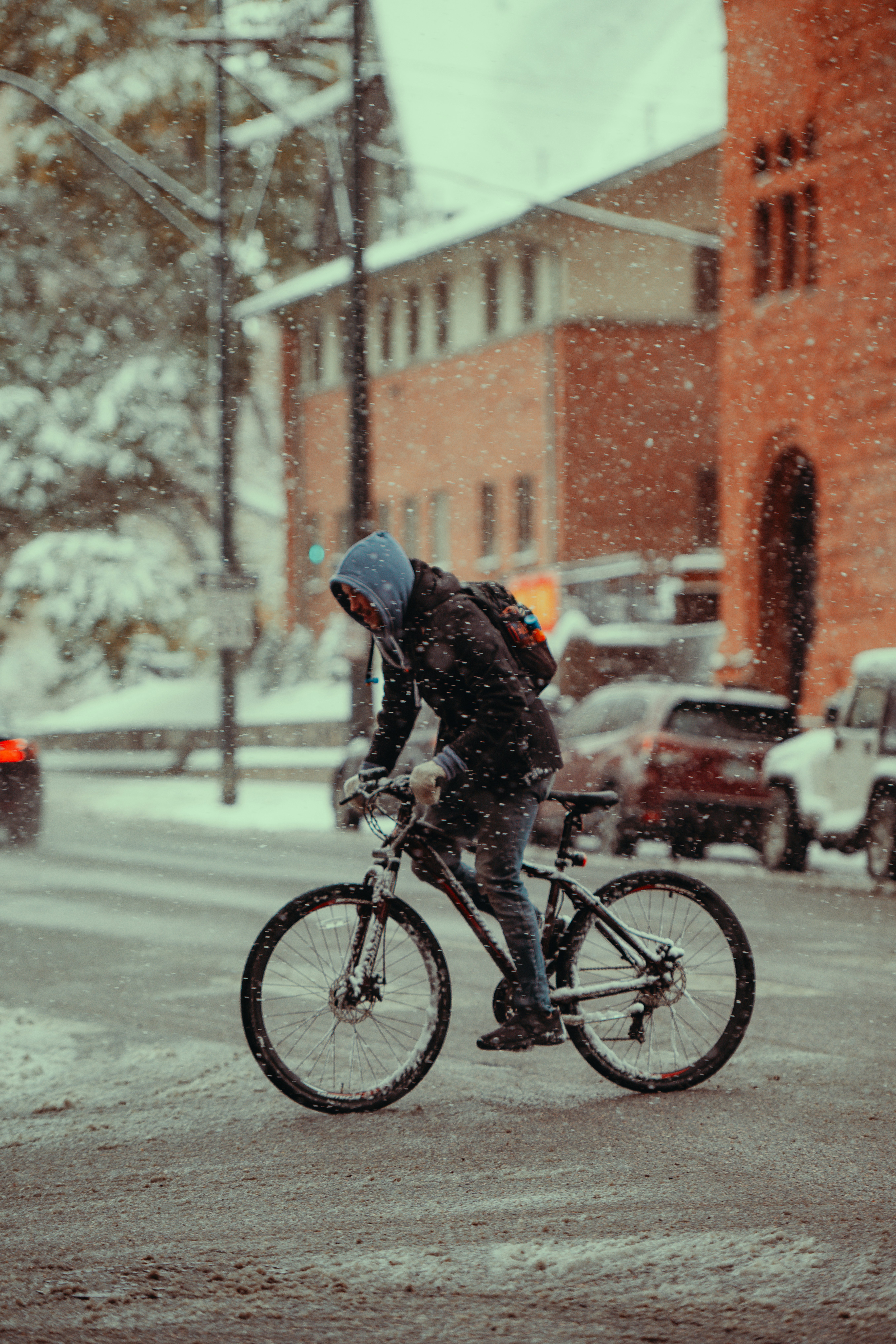 A man riding a bike down a snow covered street