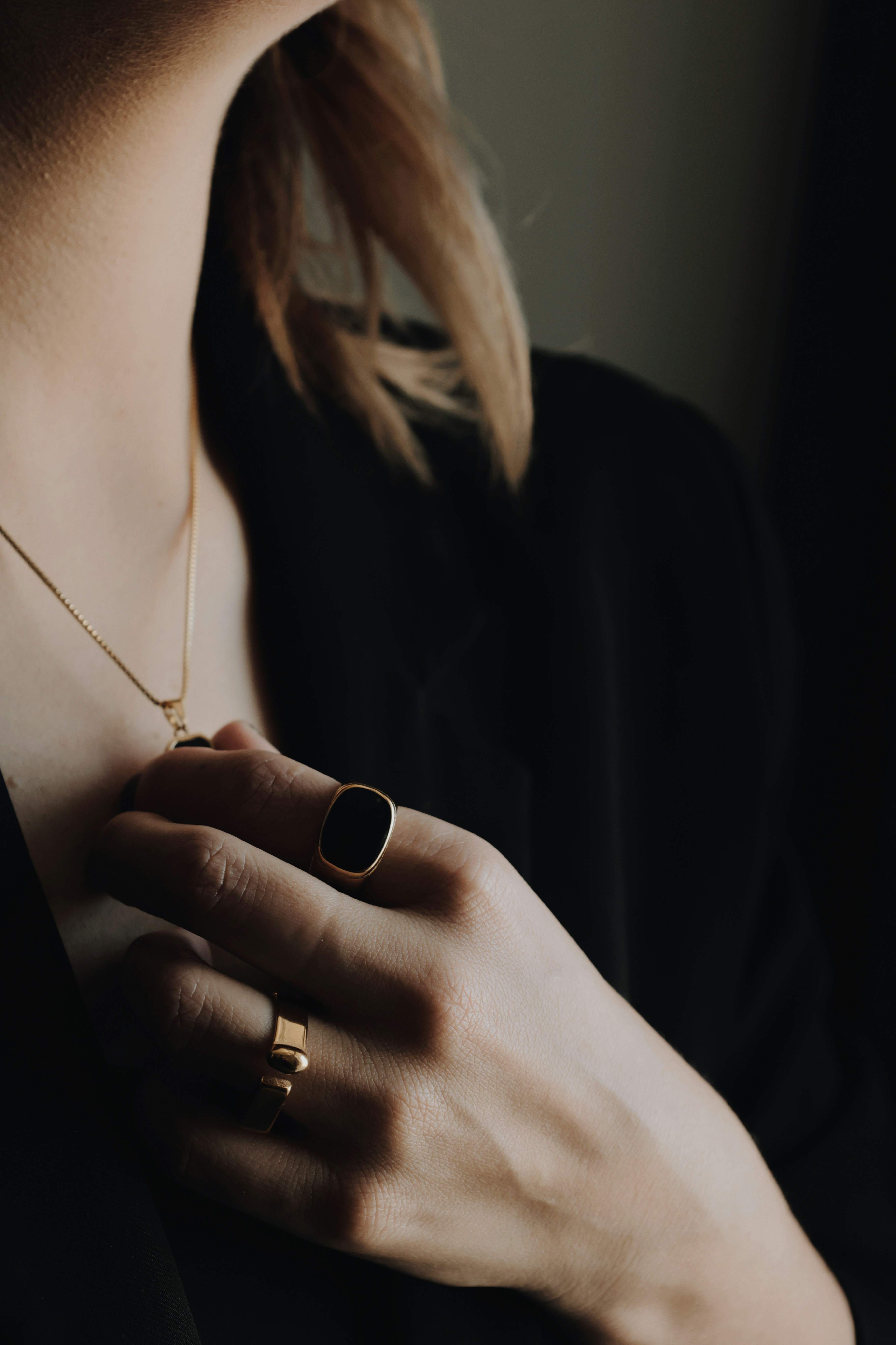 A woman wearing a black shirt and a gold necklace
