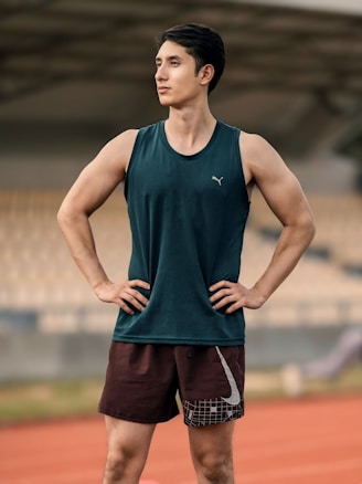 A man standing on a track with his hands on his hips