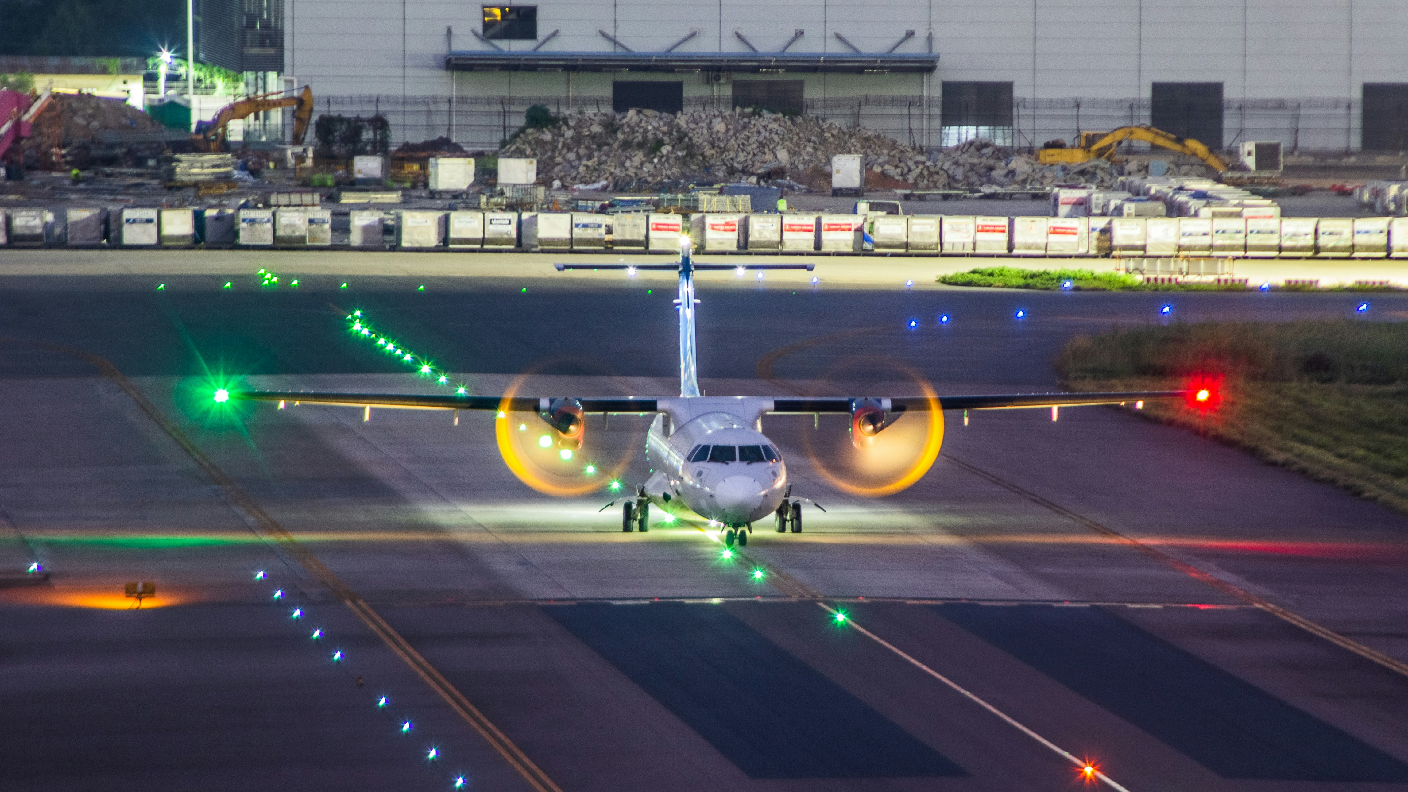 A small airplane is on the runway at night