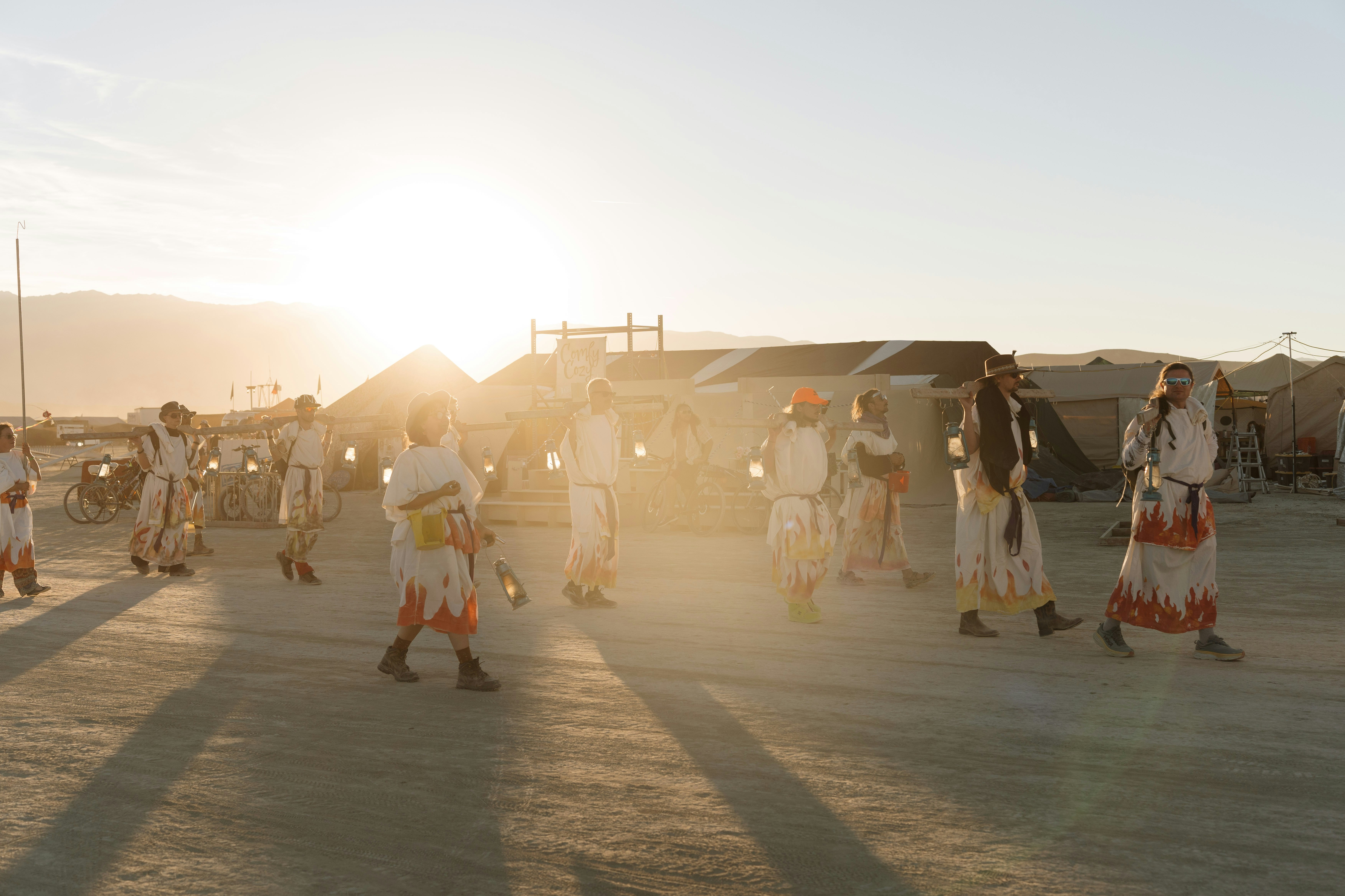 A group of people walking across a dirt field