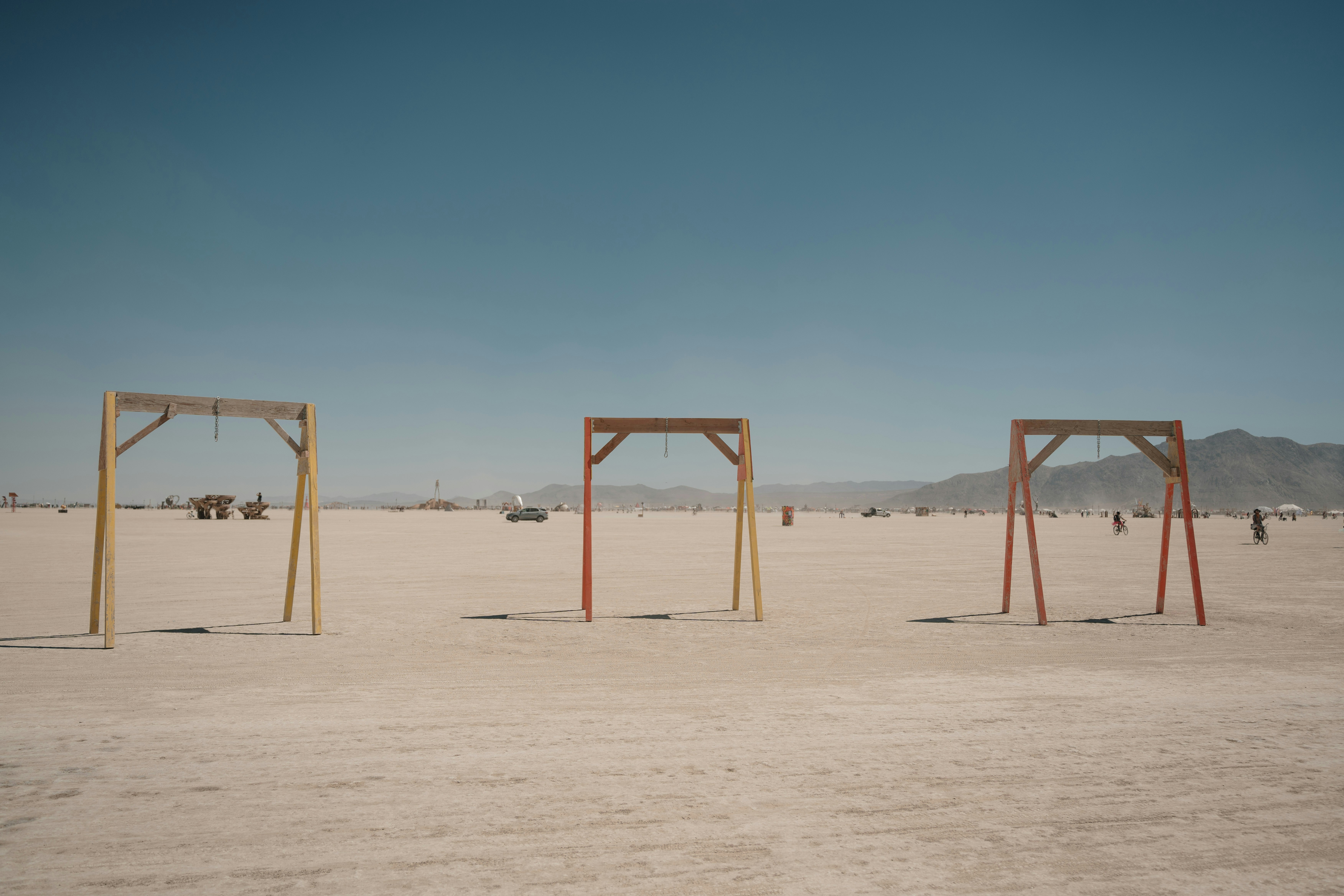 Three wooden structures in the middle of a desert