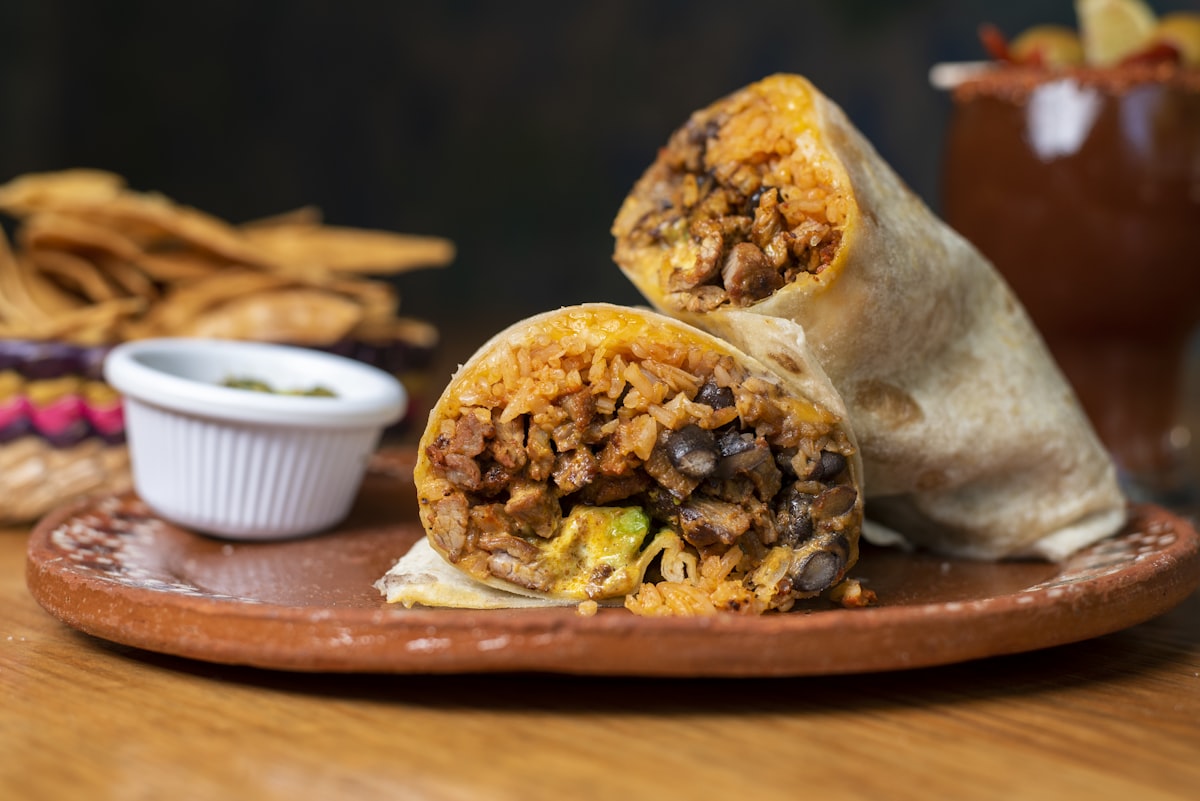Wrapped Mexican-style burrito cut in half showing seasoned beef and beans filling
