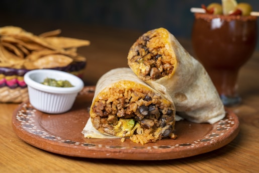 A burrito cut in half on a plate