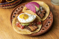 Two tacos on a plate on a wooden table