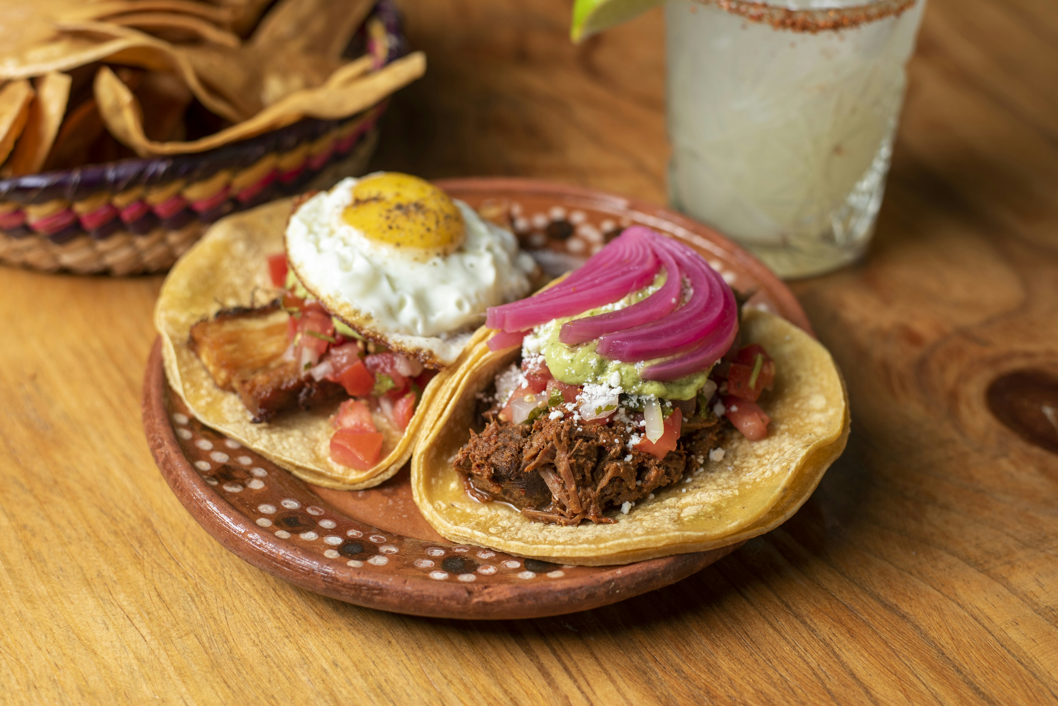 Due tacos su un piatto accanto a una bevanda