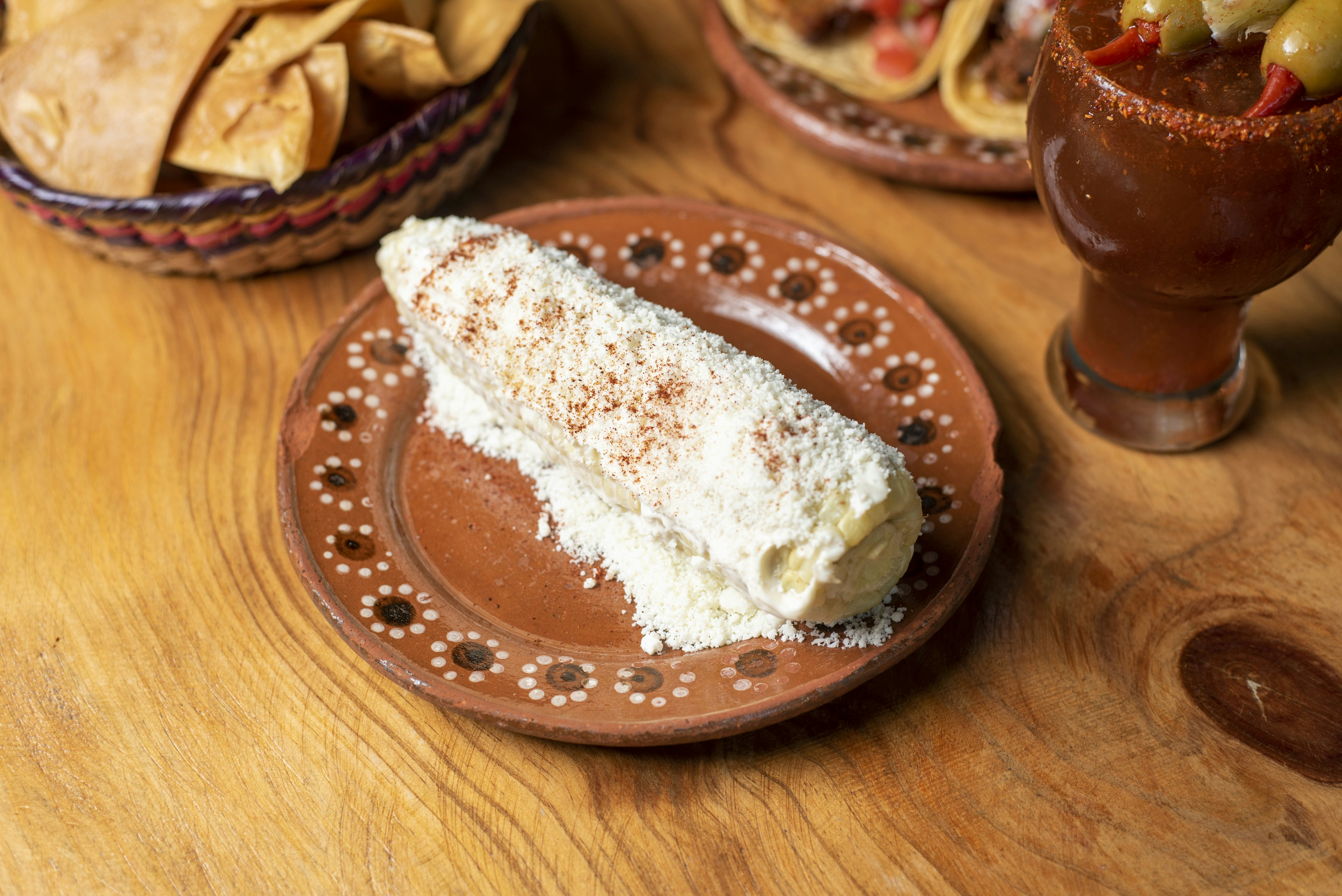 A wooden table topped with plates of food, 
