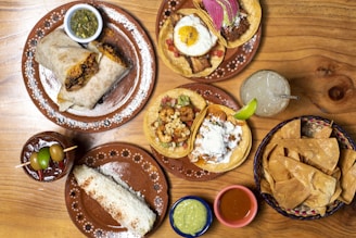 A wooden table topped with plates of food