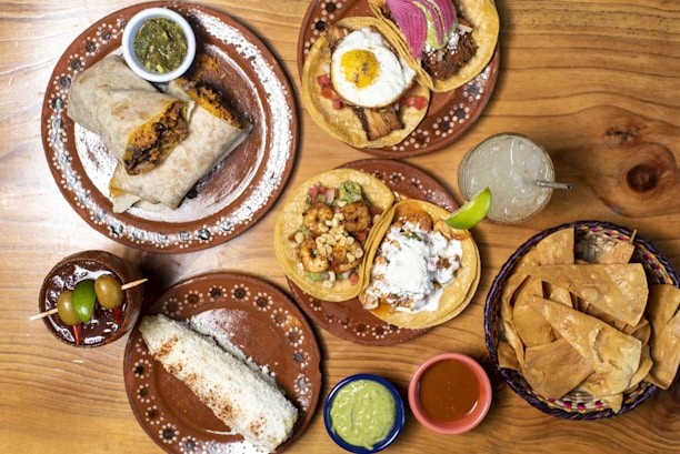 A wooden table topped with plates of food