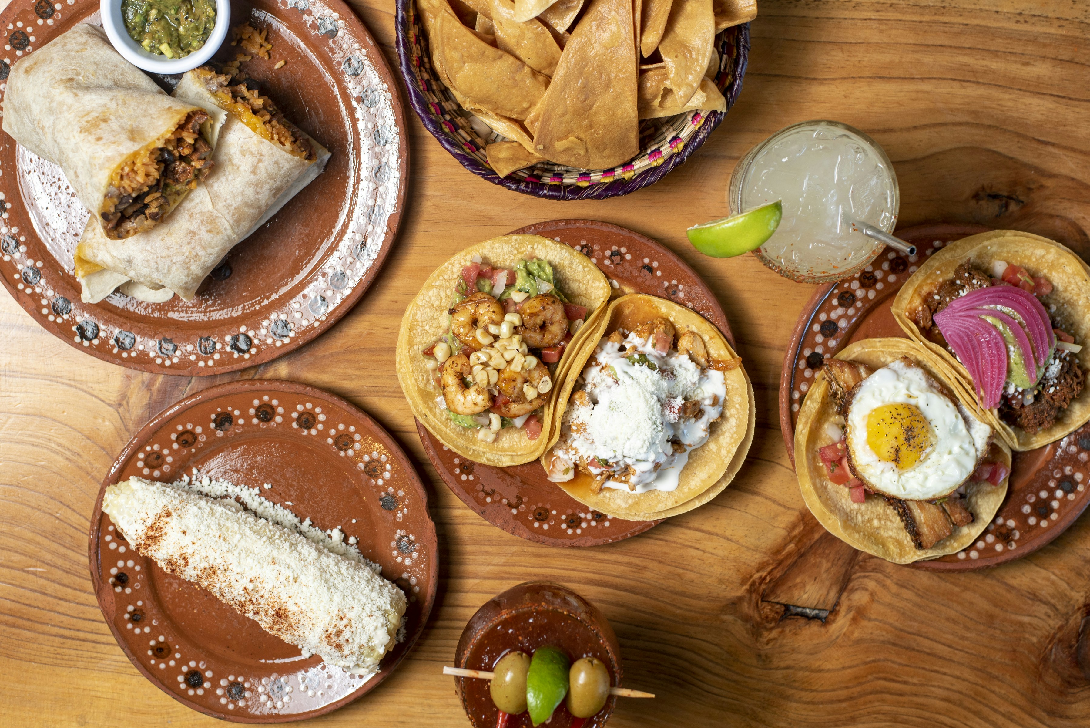 A wooden table topped with plates of food