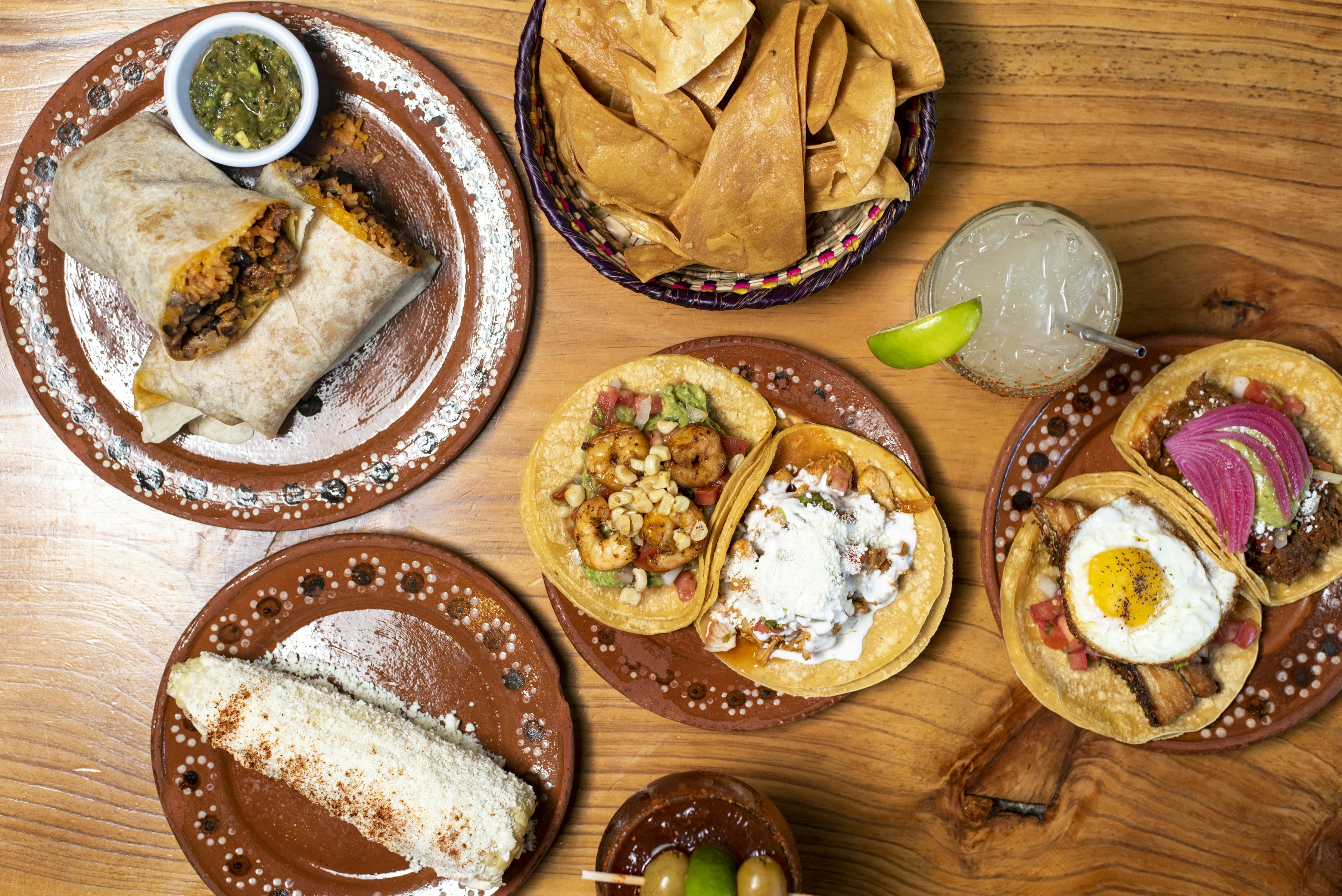 A wooden table topped with plates of food