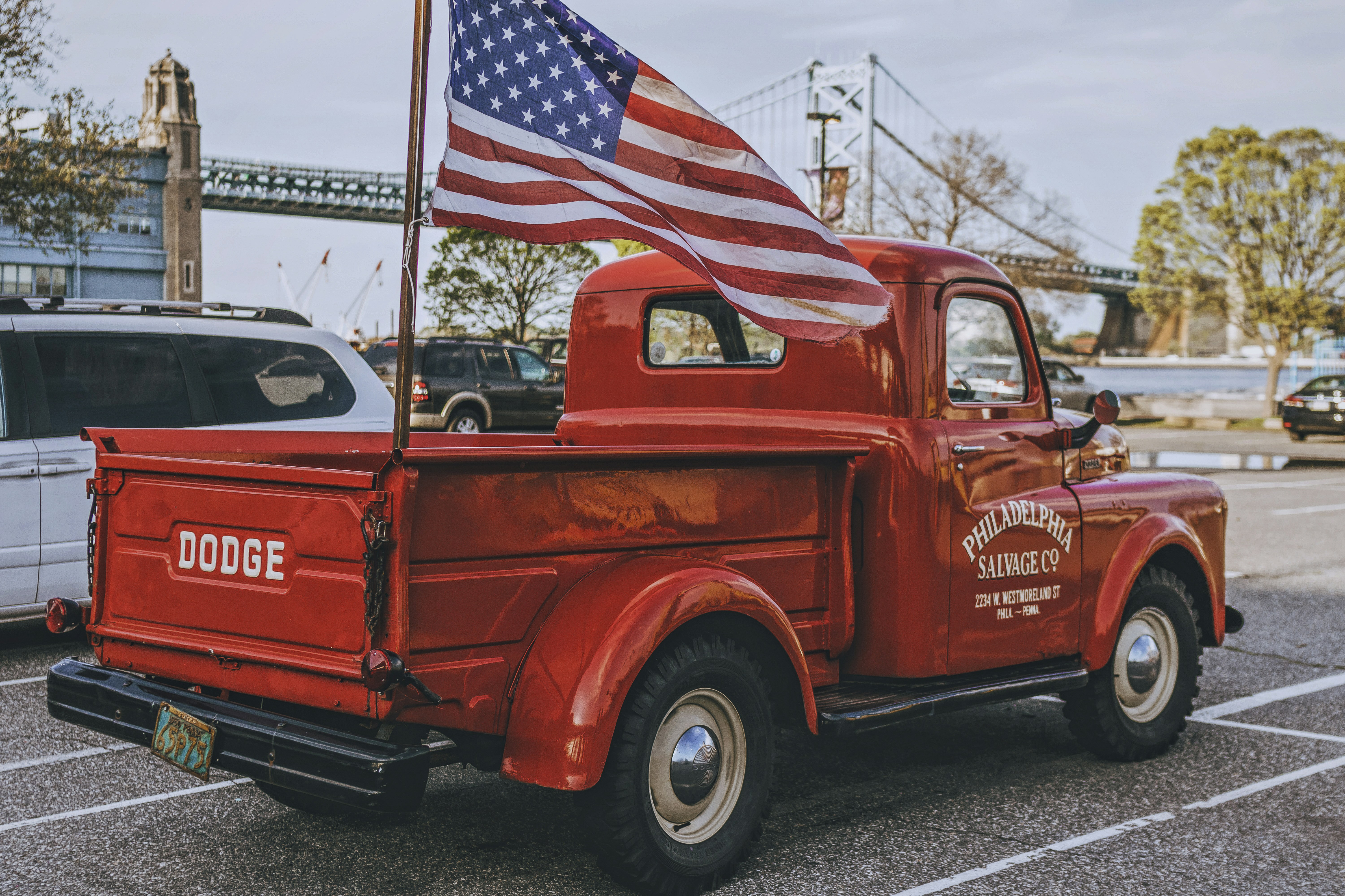 An old red truck with an american flag on the back