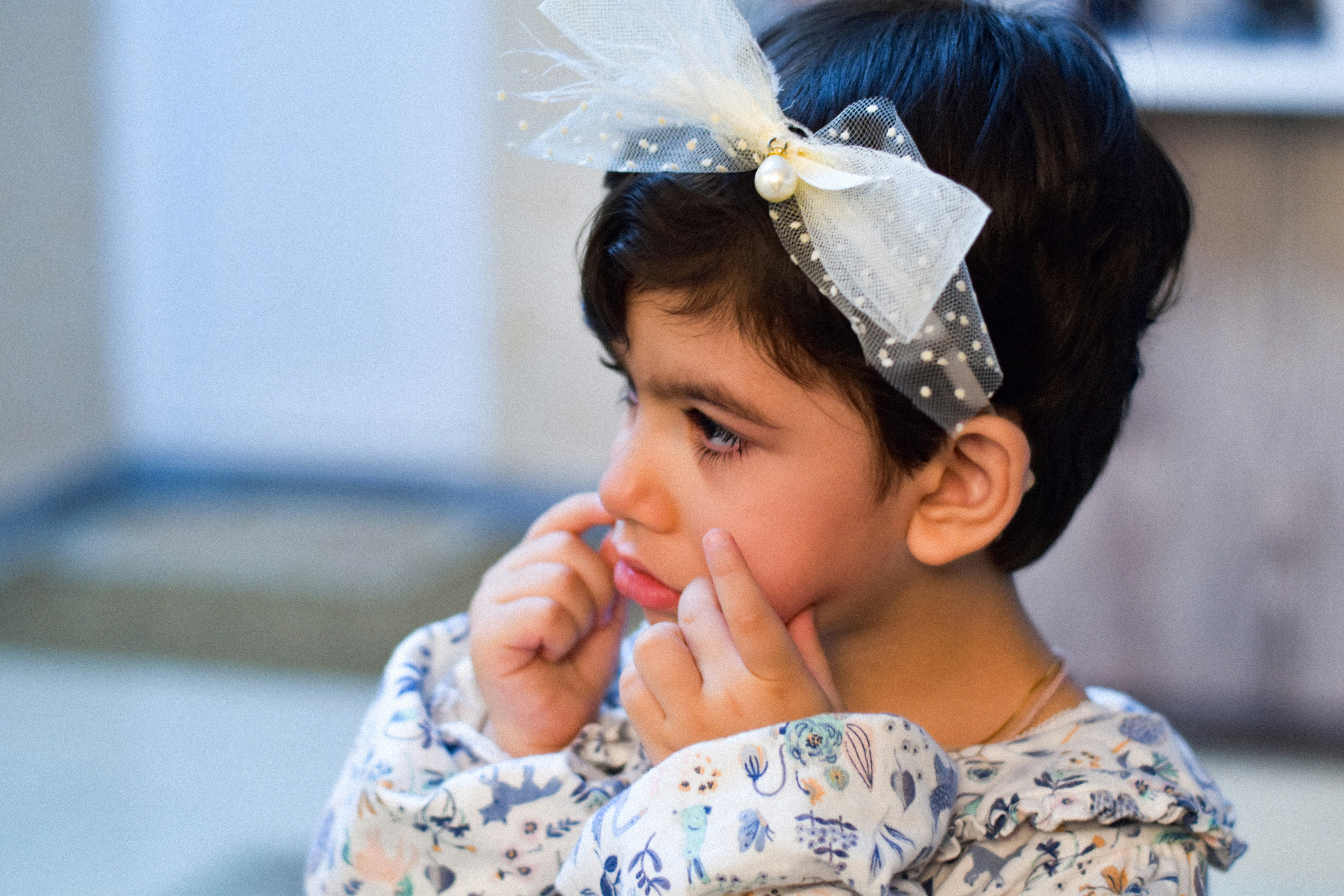 A little girl with a big bow on her head (Photo by Ali Rowshani on Unsplash)