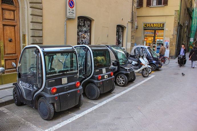 A row of cars parked on the side of a street